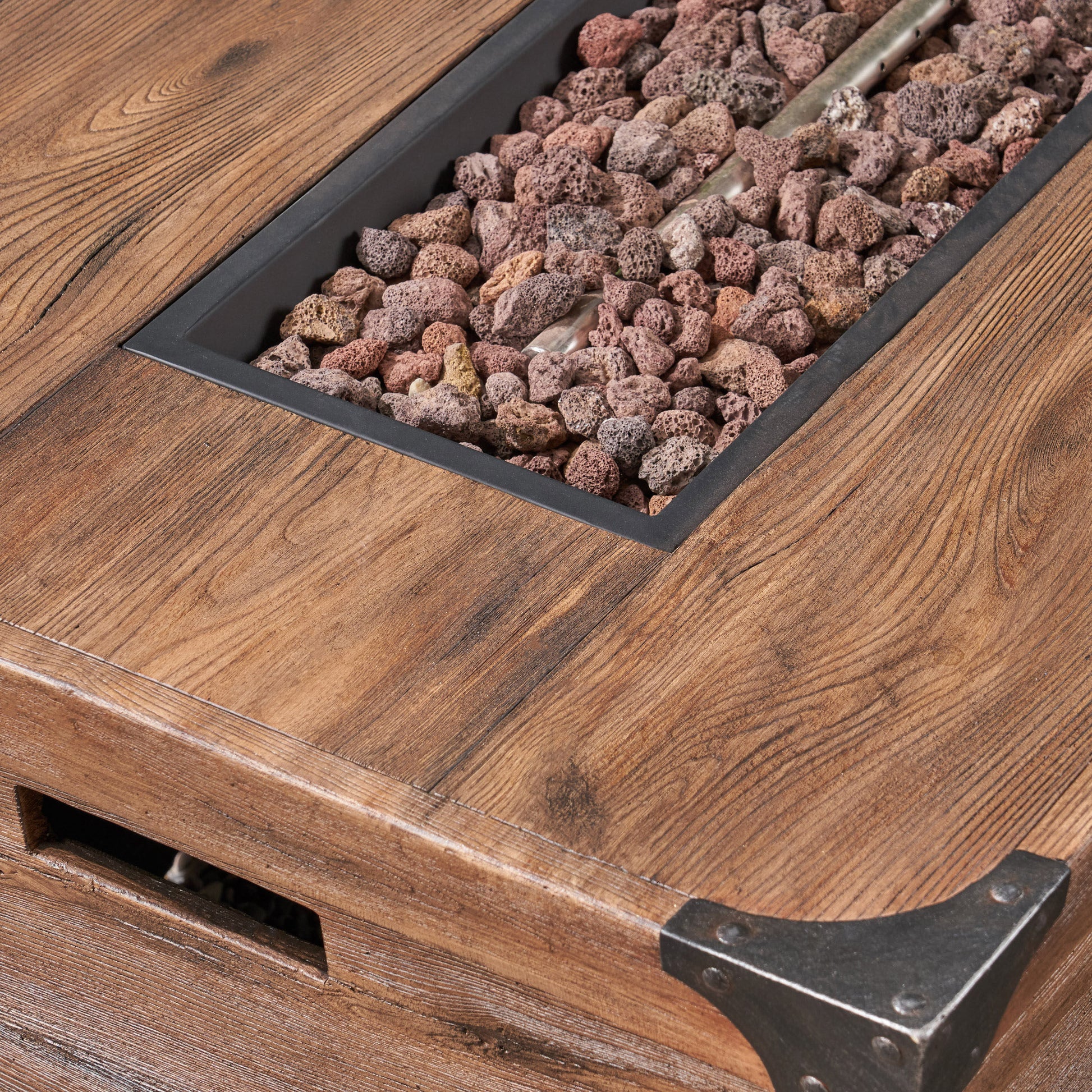 Brown wood grain coffee table with integrated gas fire pit and lava rocks