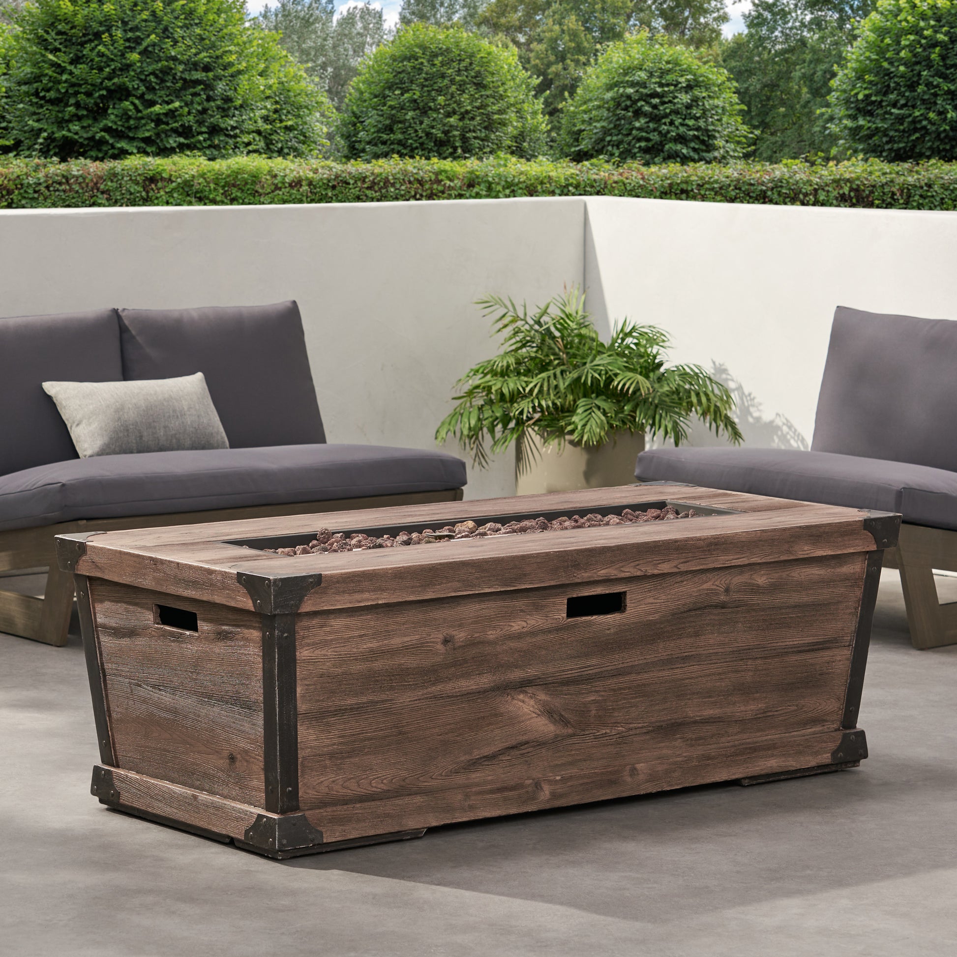 Rustic brown wood patio fire pit table with metal accents and lava rocks