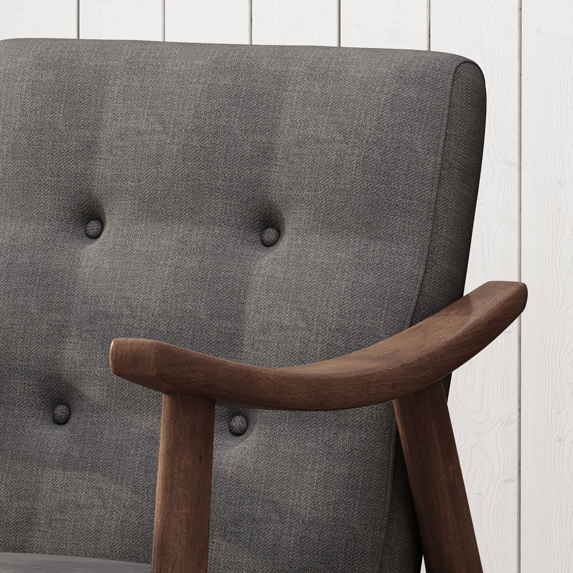 Closeup of tufted grey fabric armchair with curved wooden armrest and legs