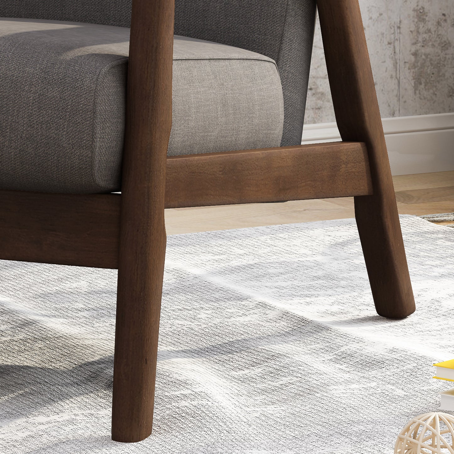 Dark brown wooden legs of a modern upholstered armchair on a textured rug