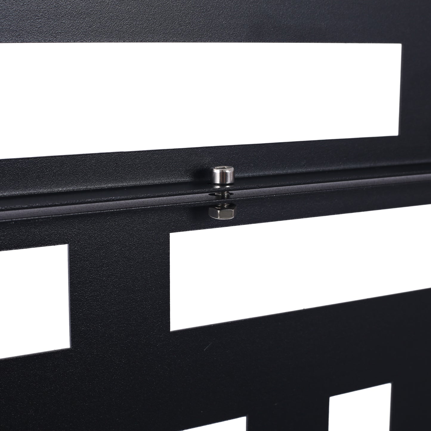 Closeup of black textured metal rack panel with geometric cutouts and silver bolt
