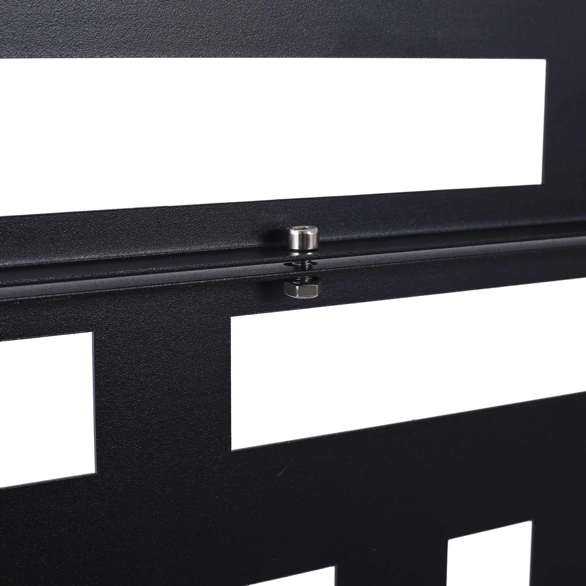 Closeup of black textured metal rack panel with geometric cutouts and silver bolt