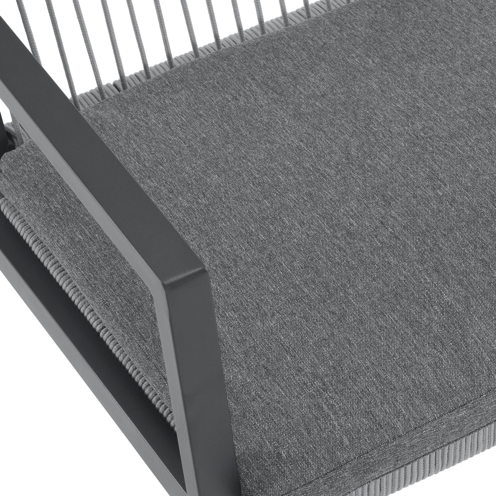 Closeup of a modern grey outdoor chair with textured fabric upholstery and dark grey metal armrest