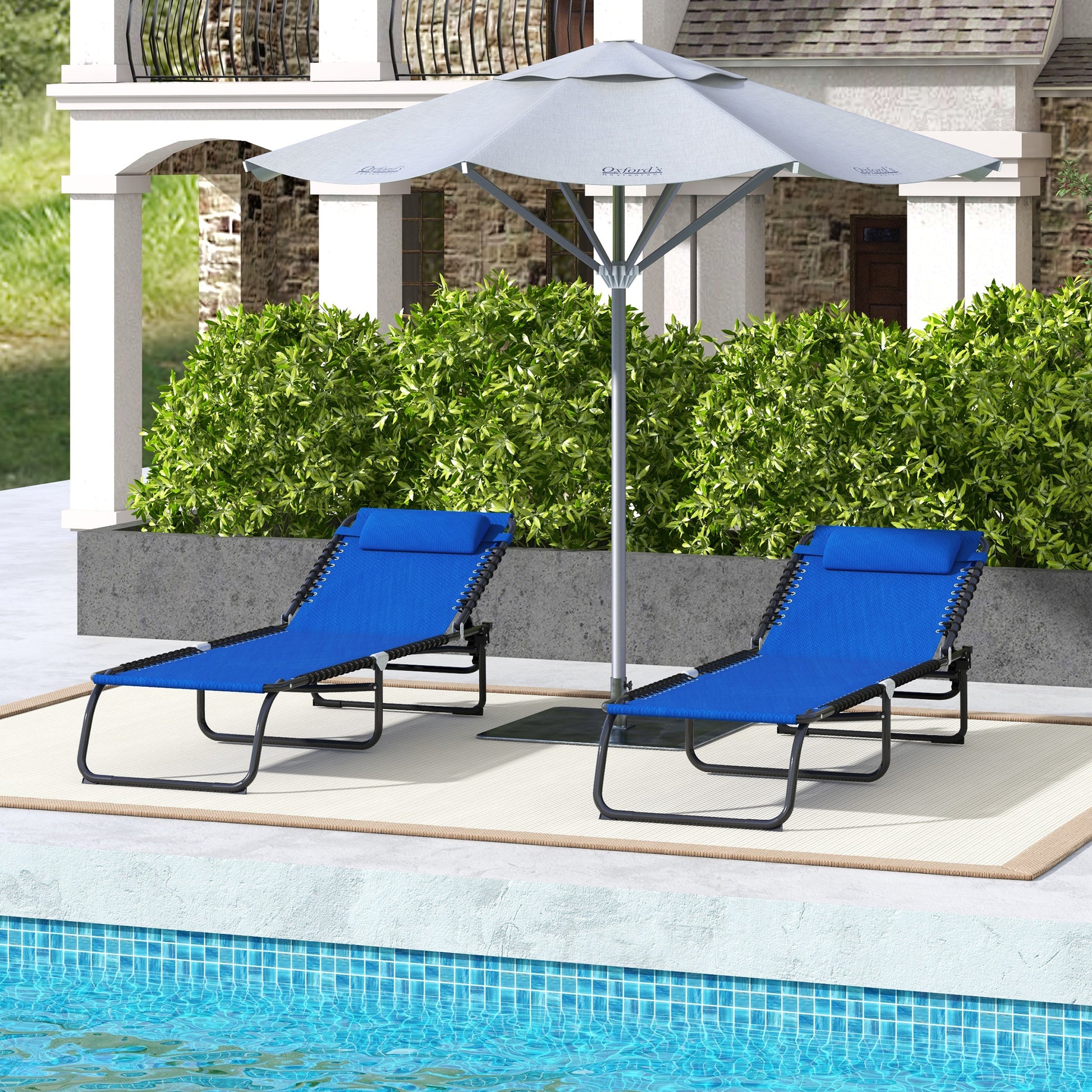 Two blue zero gravity chairs with headrests on a patio by a pool
