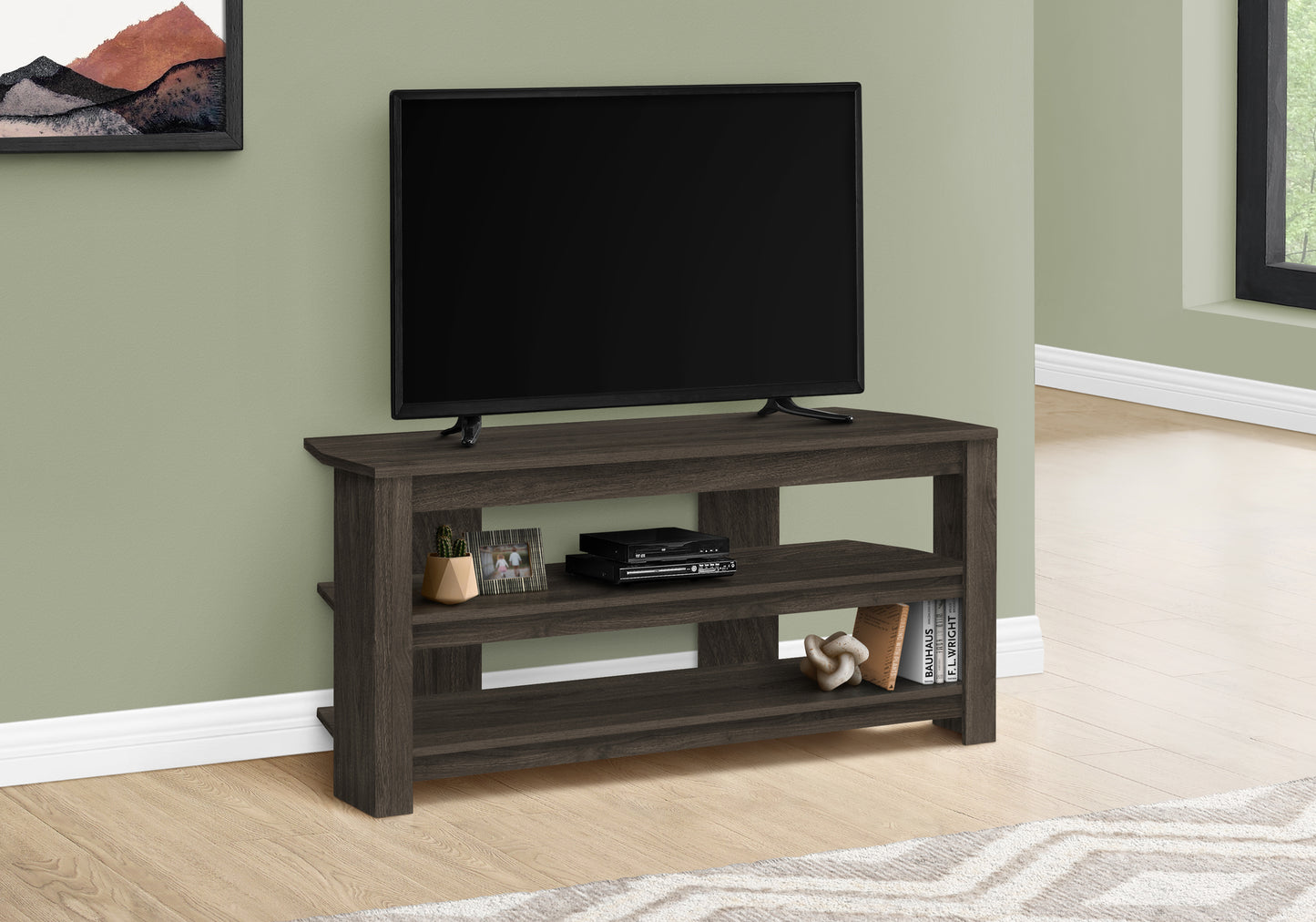 Dark wood tv stand with open shelving and a television set