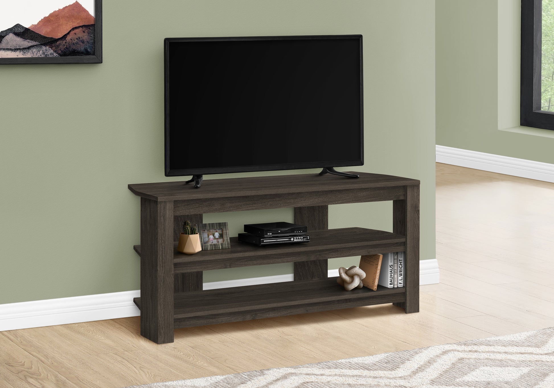 Dark wood tv stand with open shelving and a television set