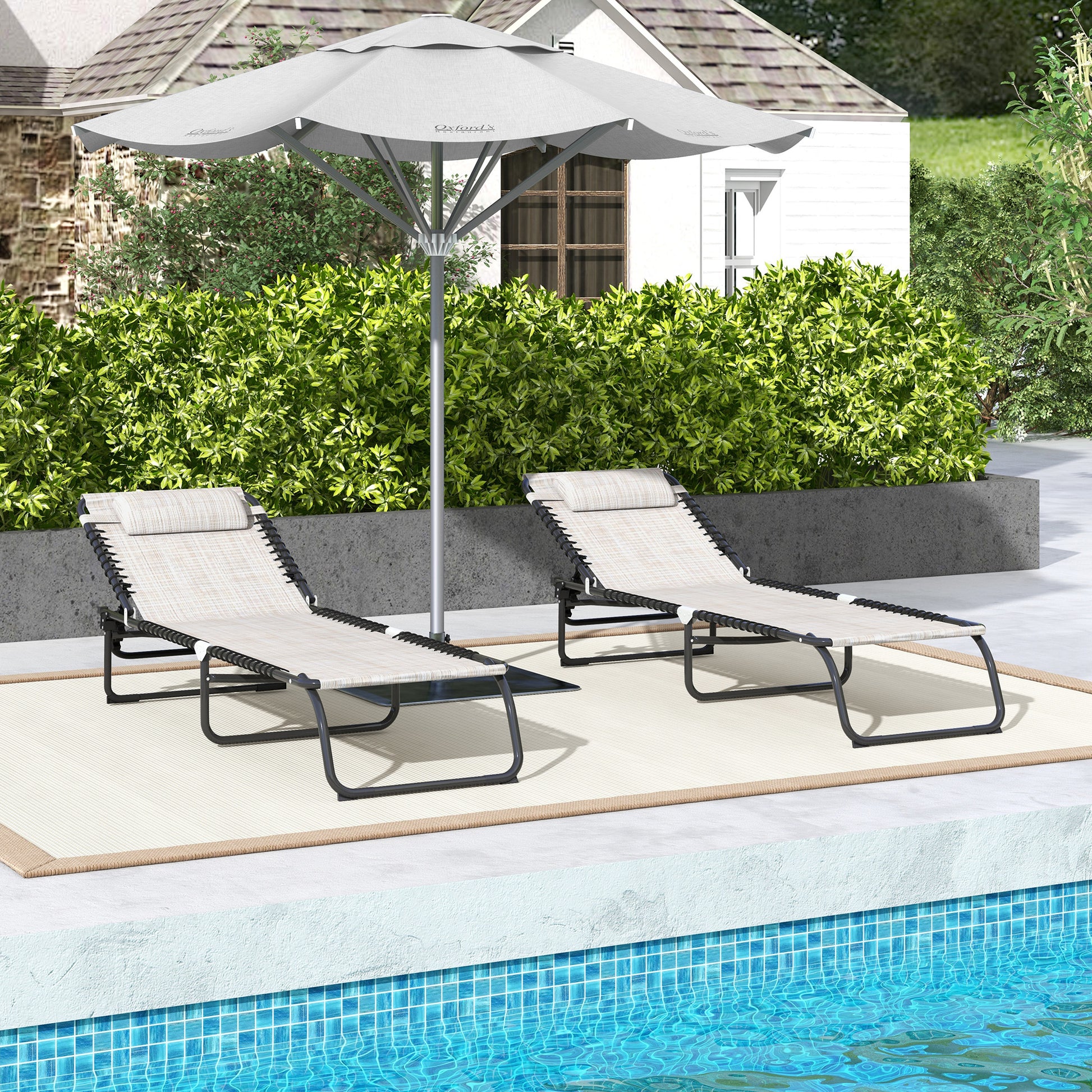 Two beige adjustable patio chaise lounges with black frames and headrests by a pool