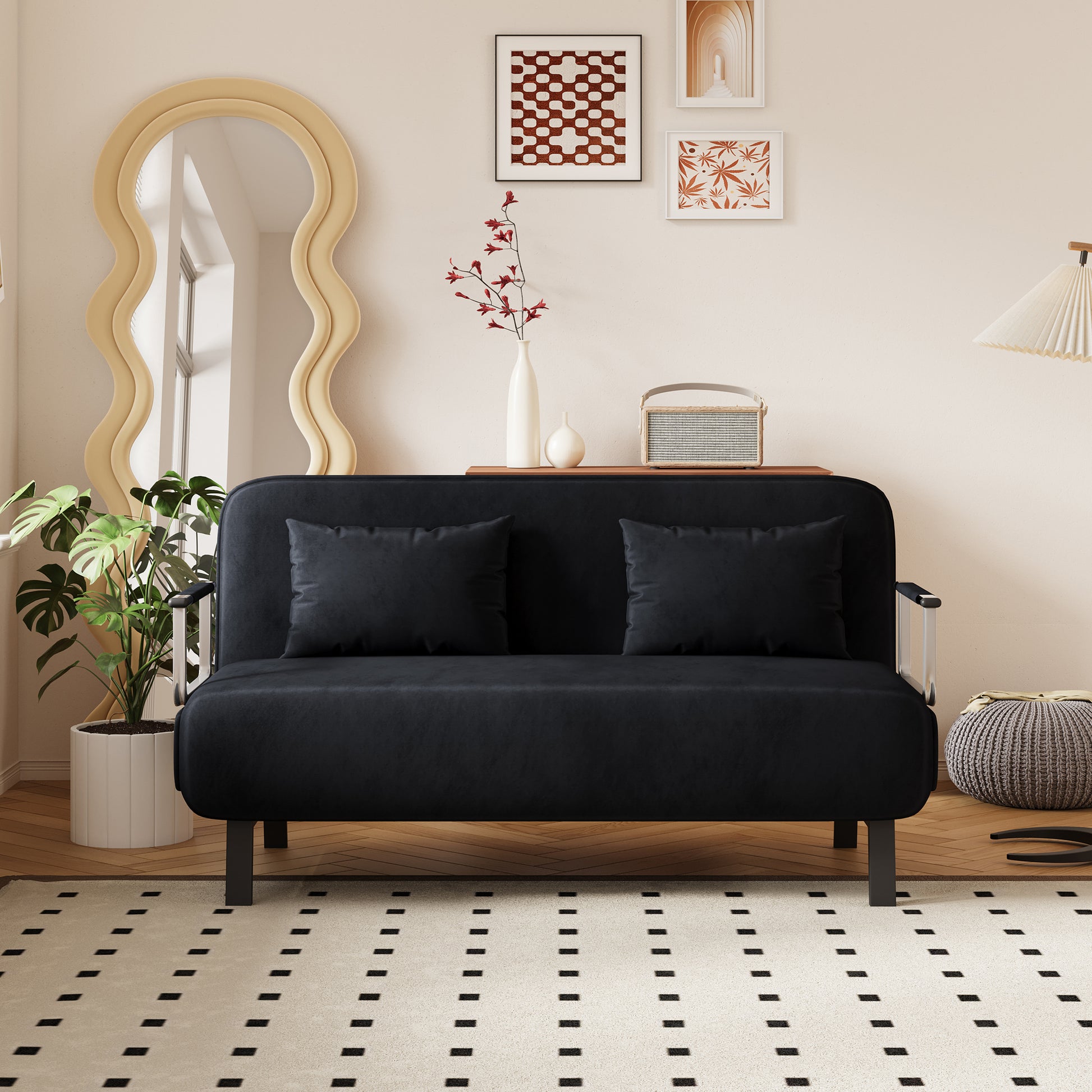 Black velvet sofa bed with two matching throw pillows on a light wood floor perfect for small apartments