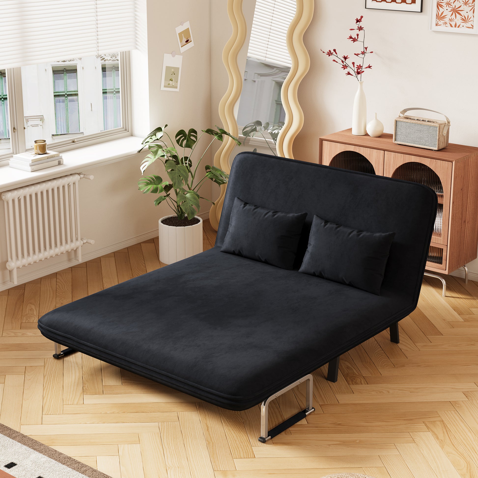 Sleek black velvet futon sofa bed with two matching accent pillows perfect for small spaces