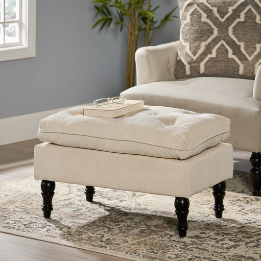 Tufted beige fabric ottoman with dark wood legs perfect as a footrest