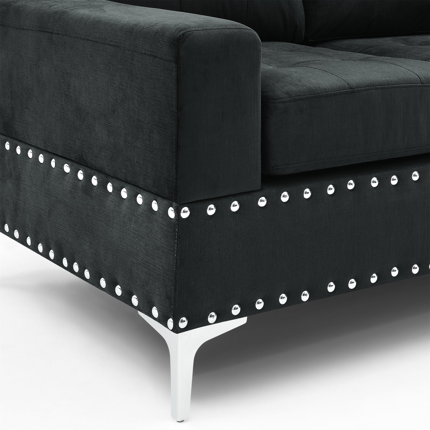 Black fabric couch armrest with silver nailhead trim and modern metal leg