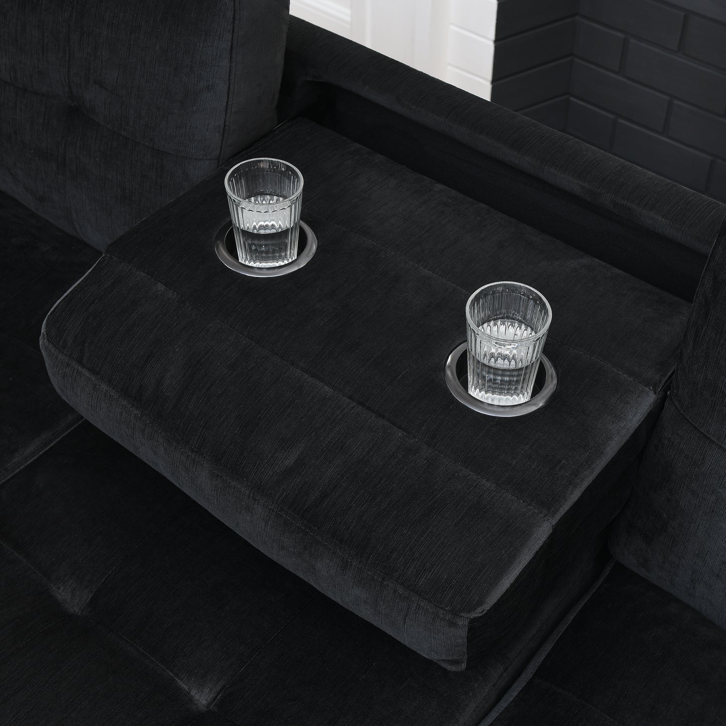 Black fabric sofa with integrated cupholders and glasses for drinks perfect for relaxation