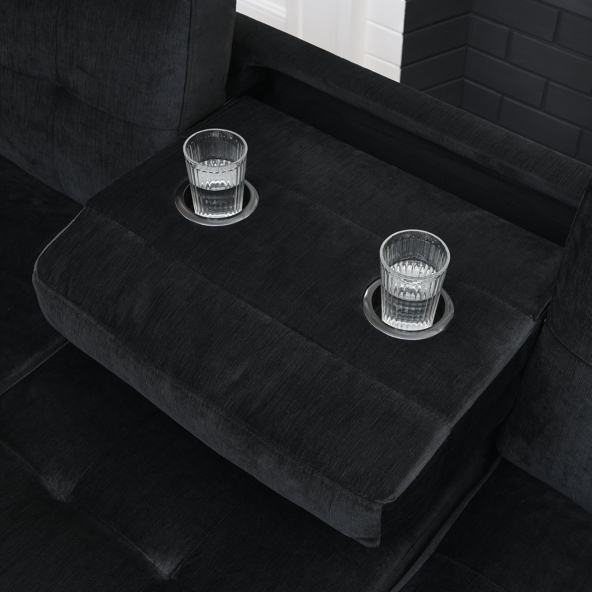 Black fabric sofa with integrated cupholders and glasses for drinks perfect for relaxation