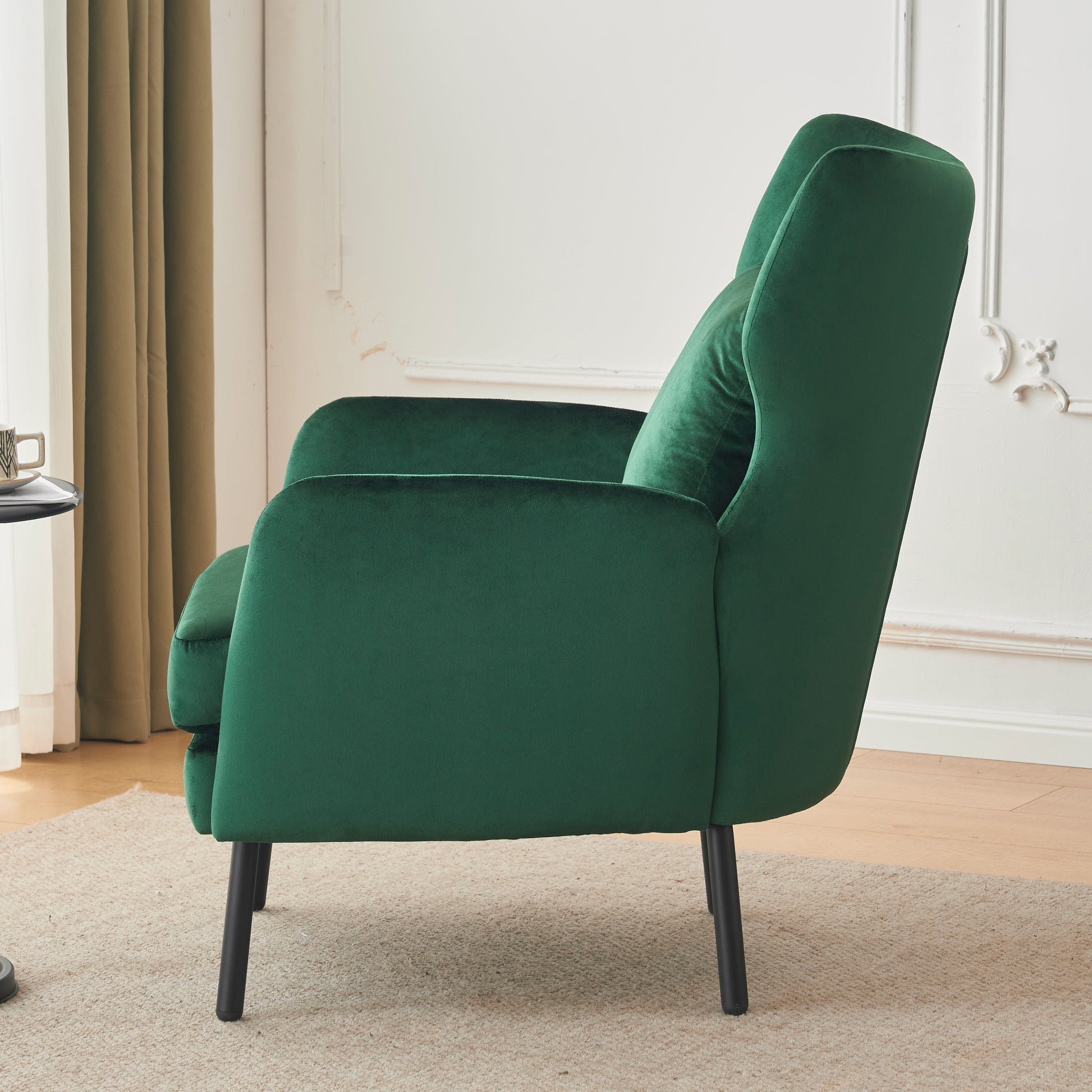 Deep emerald green velvet armchair with black tapered legs plush comfort