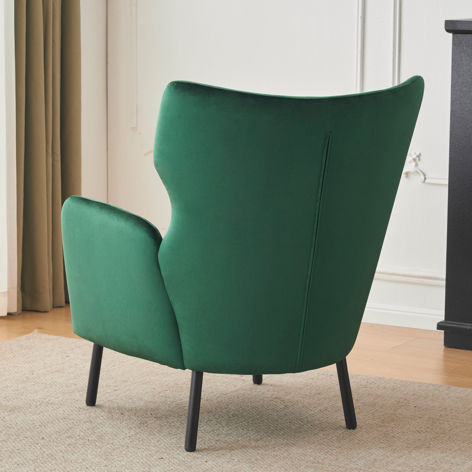 Emerald green velvet accent chair with tapered black legs