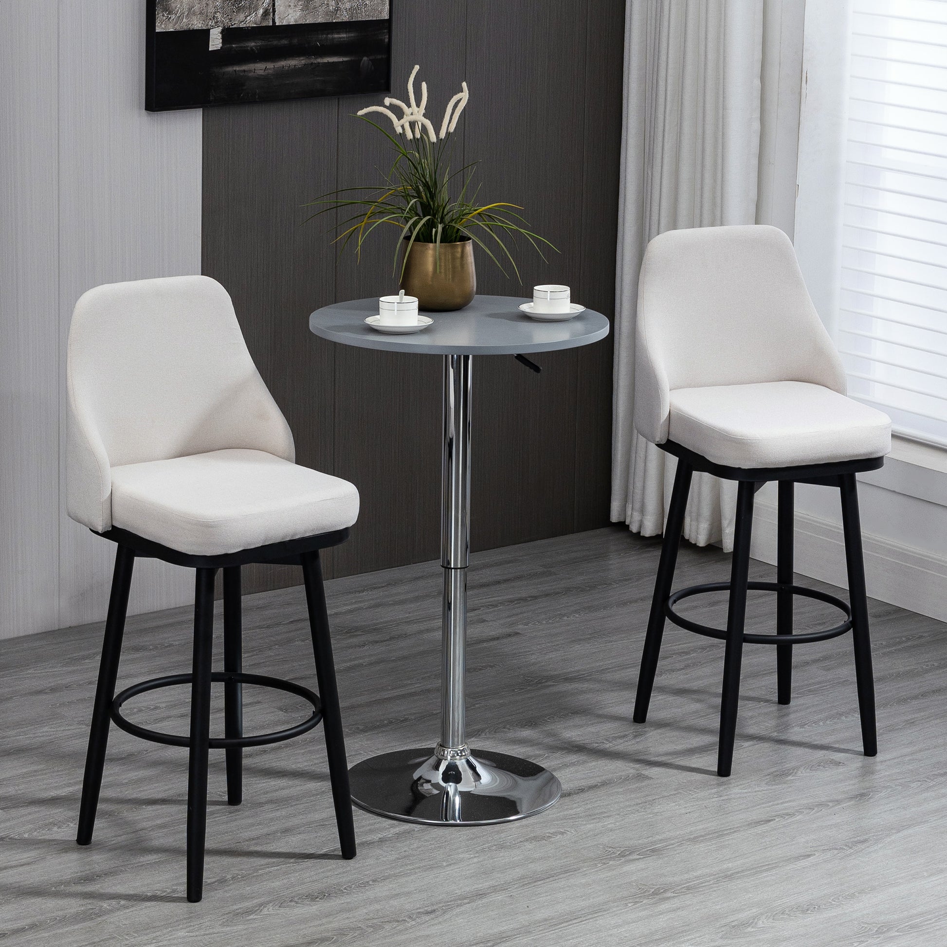 Cream upholstered bar stool with black wooden legs and a footrest ring ready for use
