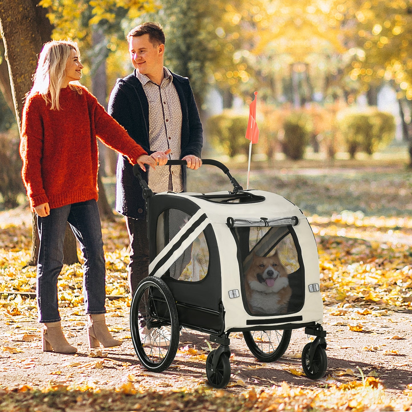 Cream and black dog stroller with mesh windows and a happy corgi inside pushed by a couple