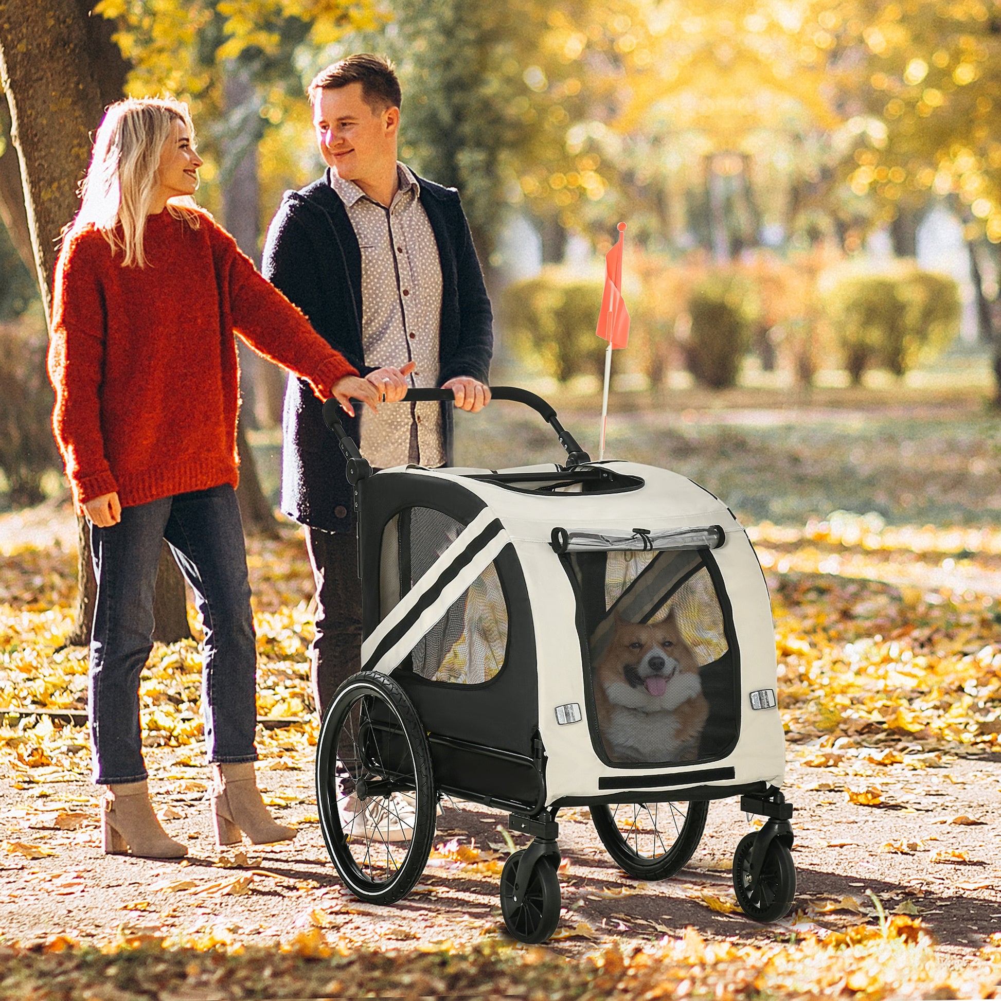 Cream and black dog stroller with mesh windows and a happy corgi inside pushed by a couple