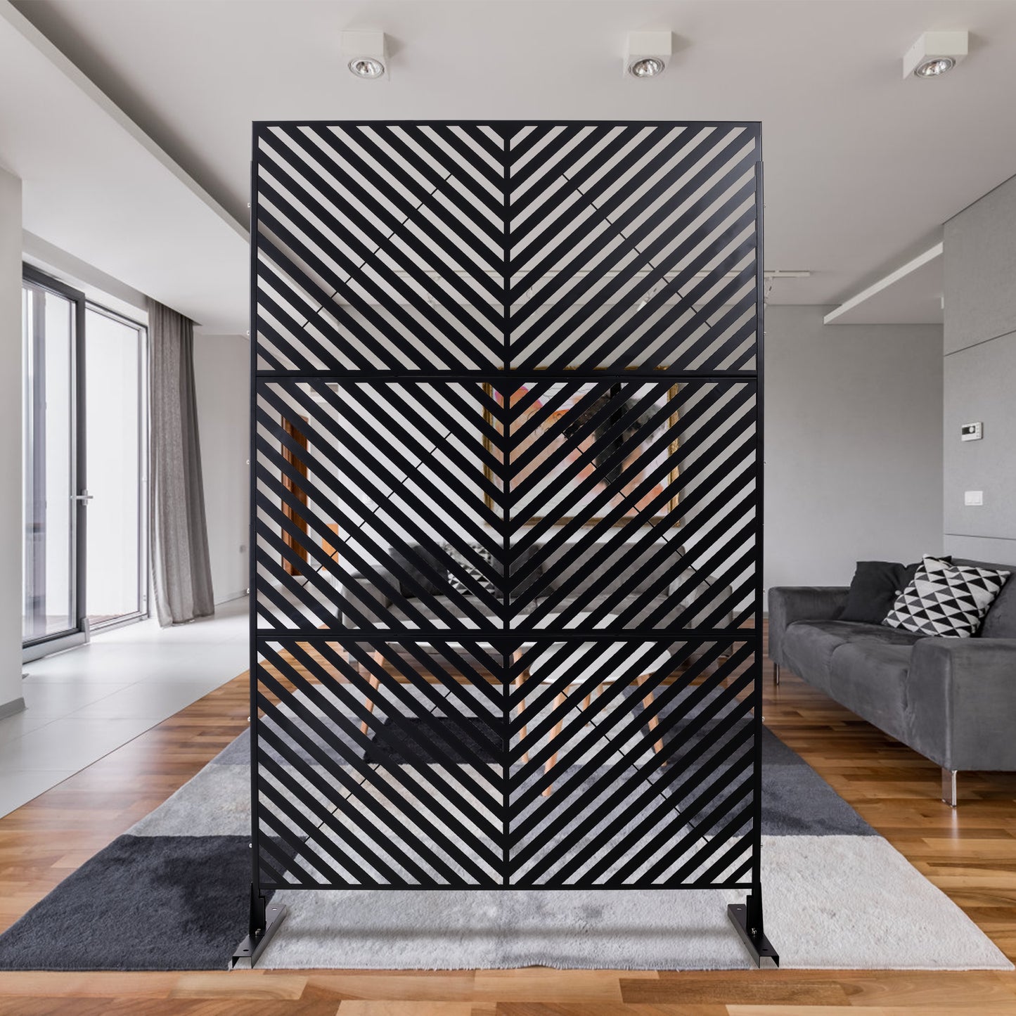 Modern black metal room divider with chevron pattern creating defined spaces