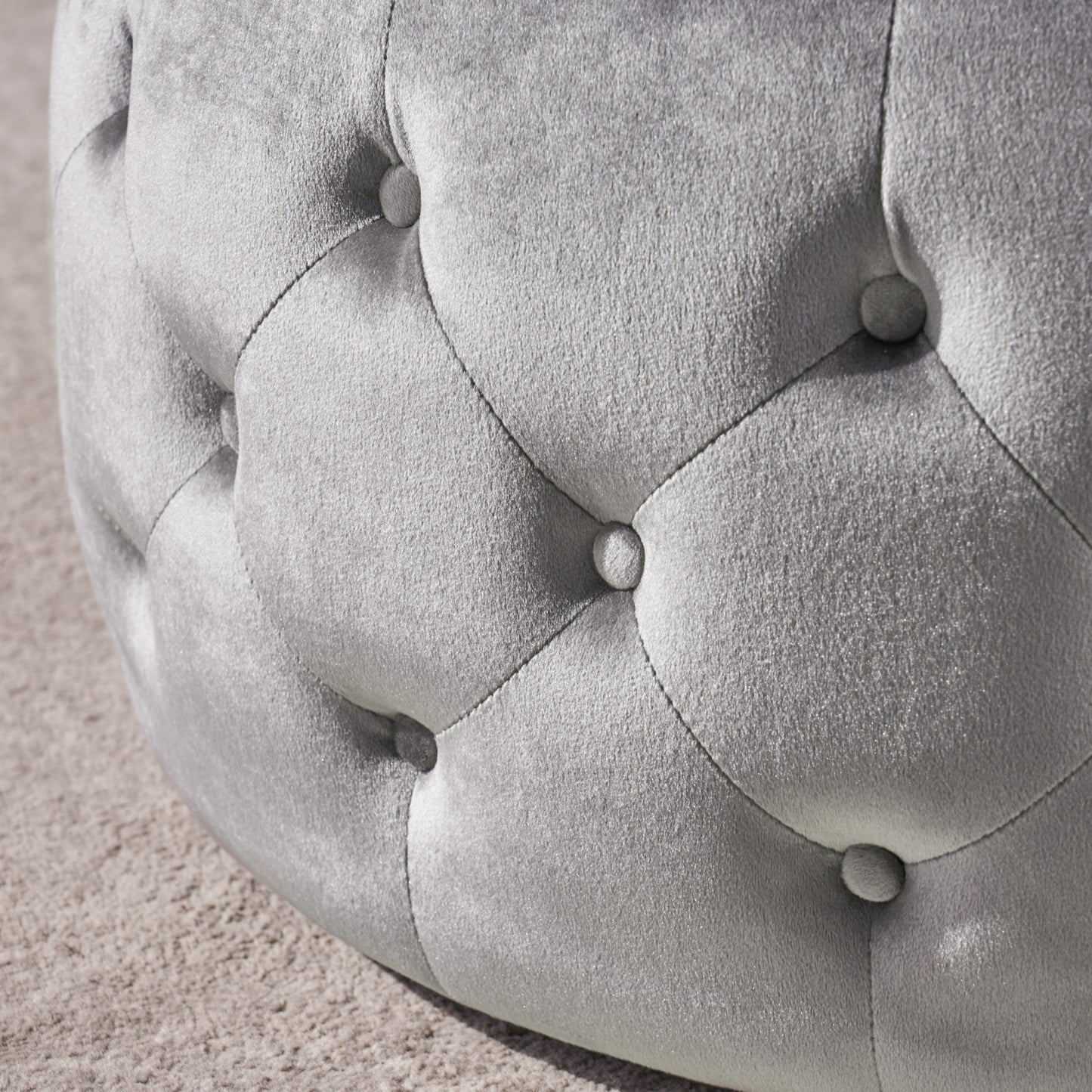Silver velvet tufted ottoman detail on carpet