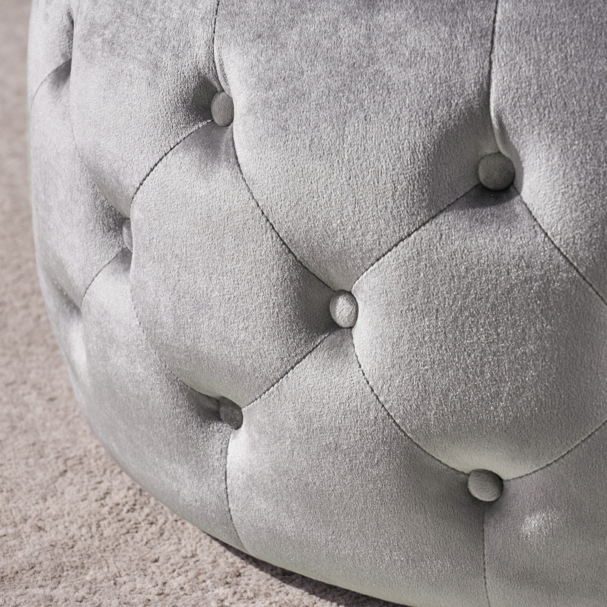 Silver velvet tufted ottoman detail on carpet