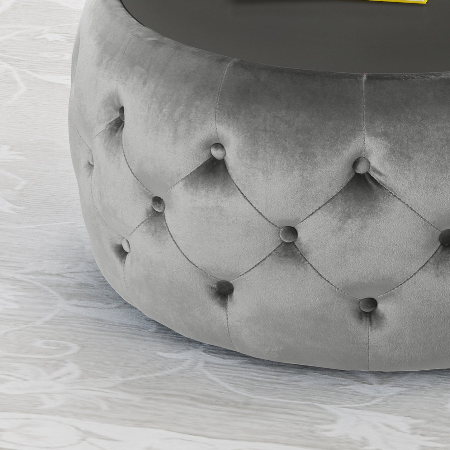 Gray velvet tufted ottoman with a circular glass top