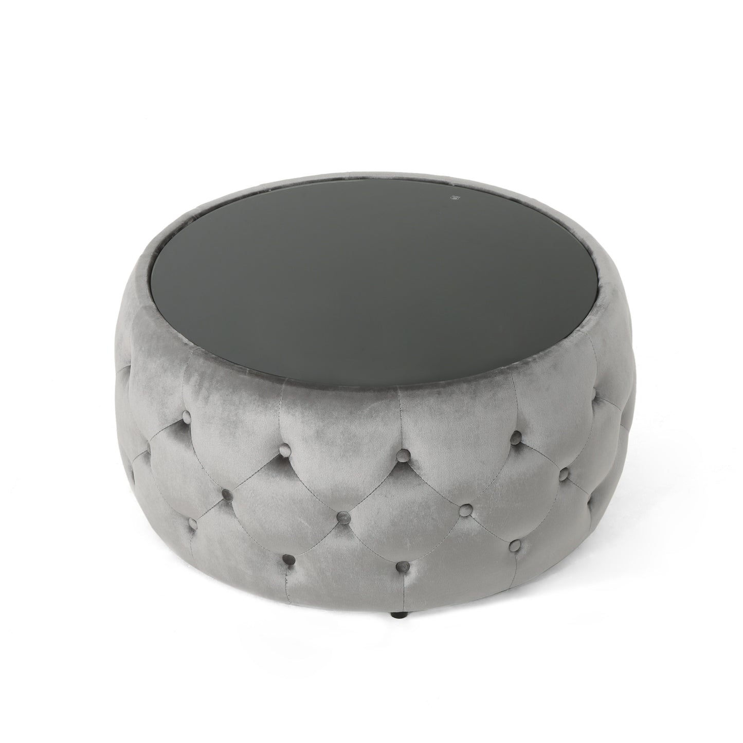 Round grey velvet ottoman with tufted detailing and a dark glass top