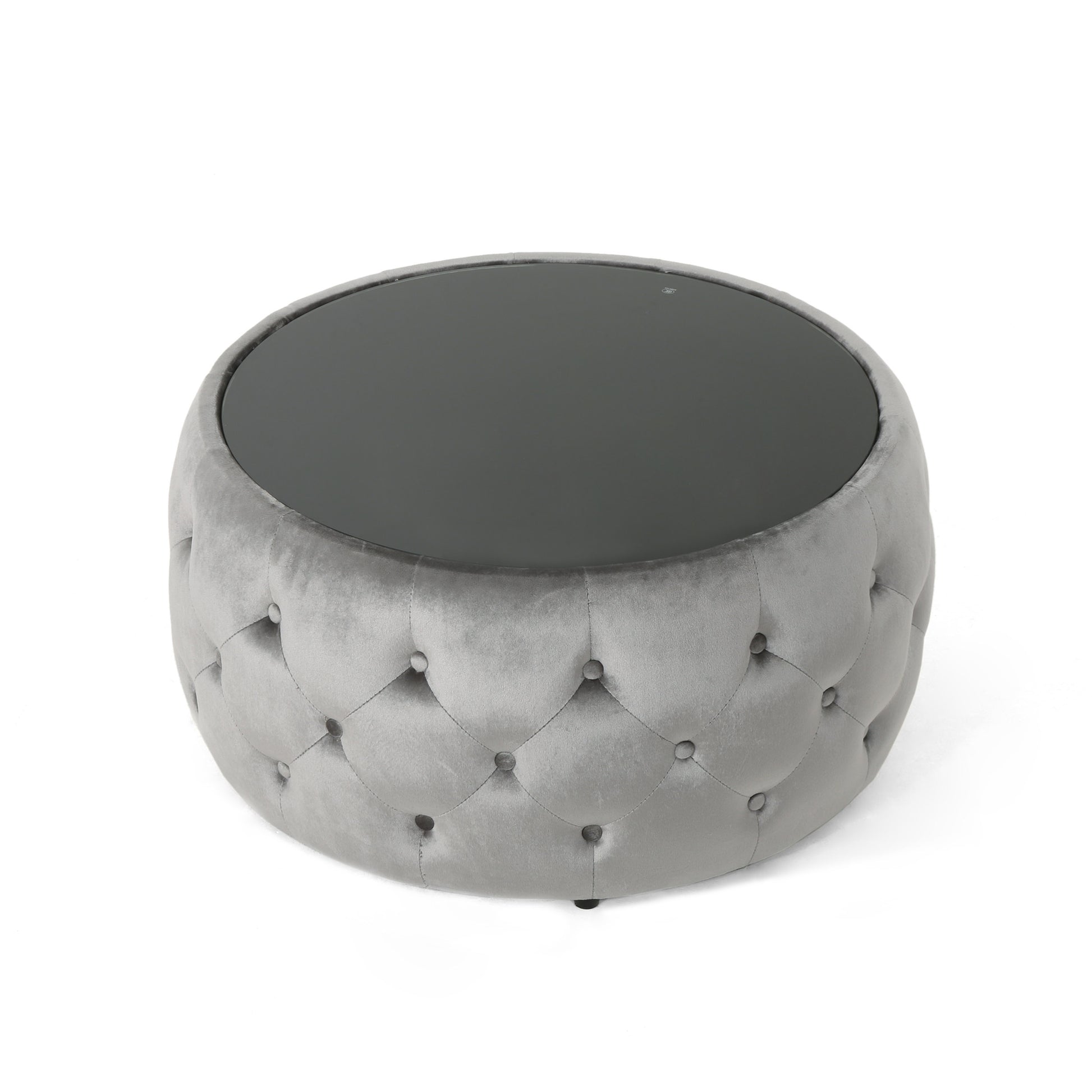 Round grey velvet ottoman with tufted detailing and a dark glass top