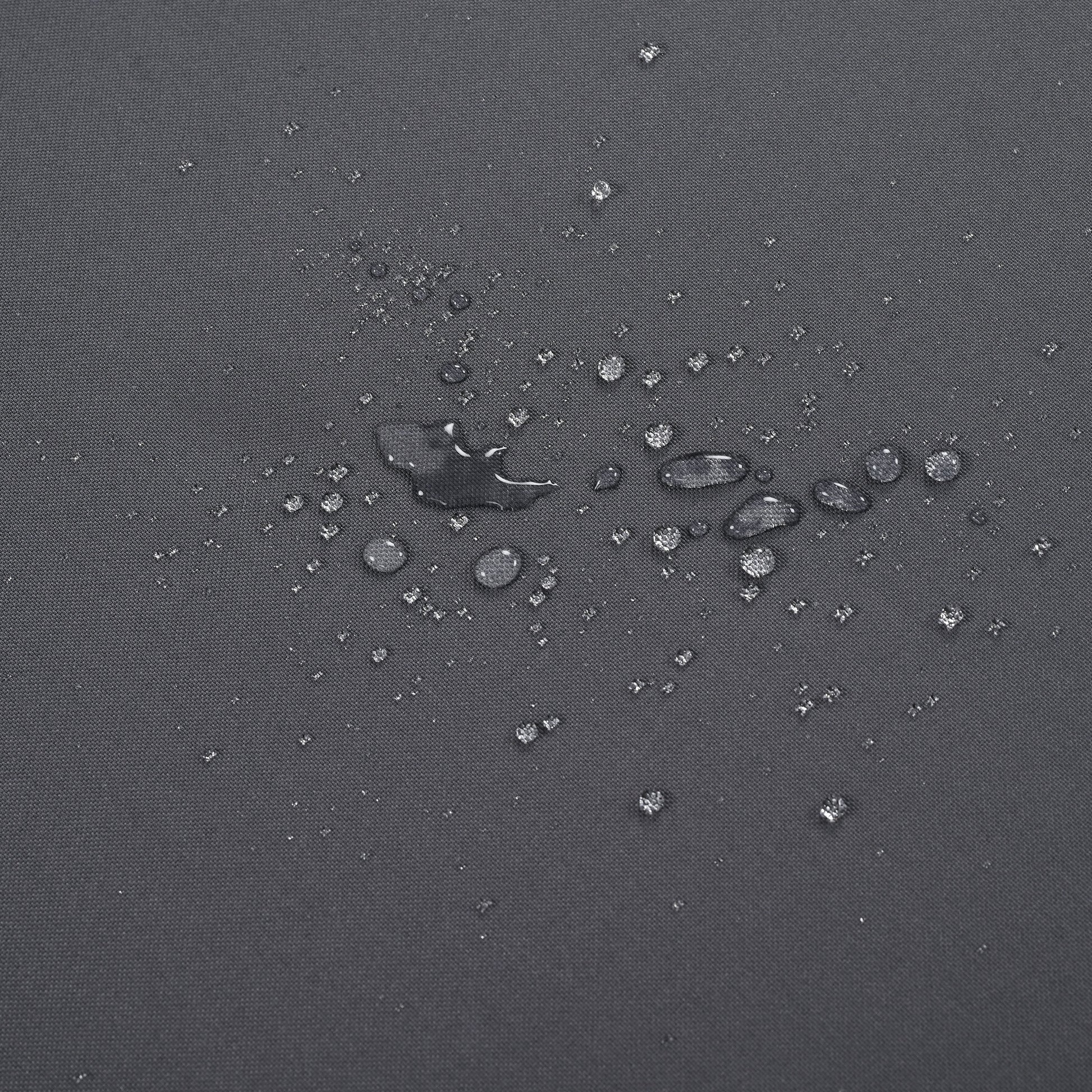 Closeup of water beads on dark grey waterproof fabric texture