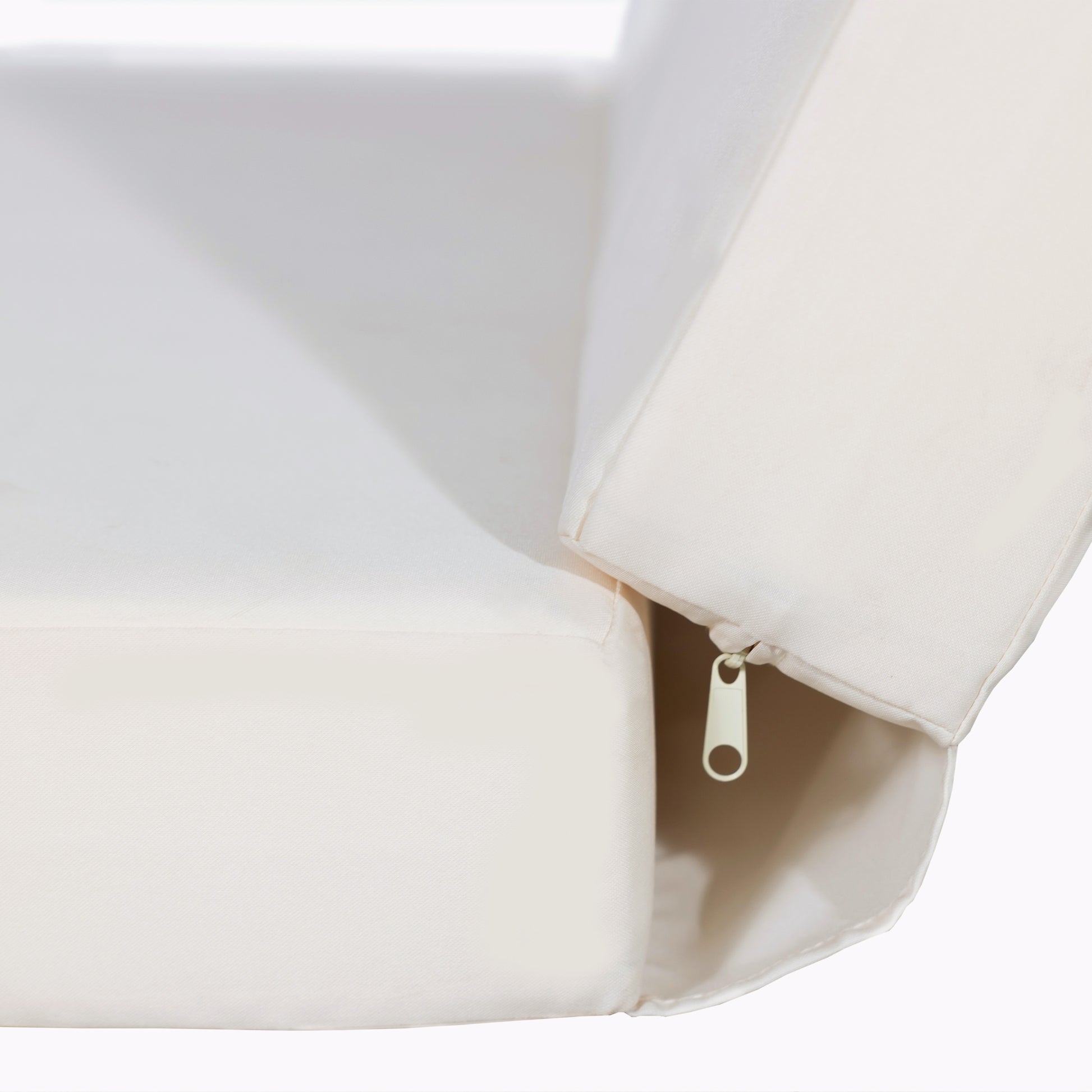 Closeup of a textured cream sofa cushion with a visible zipper detail for easy cleaning