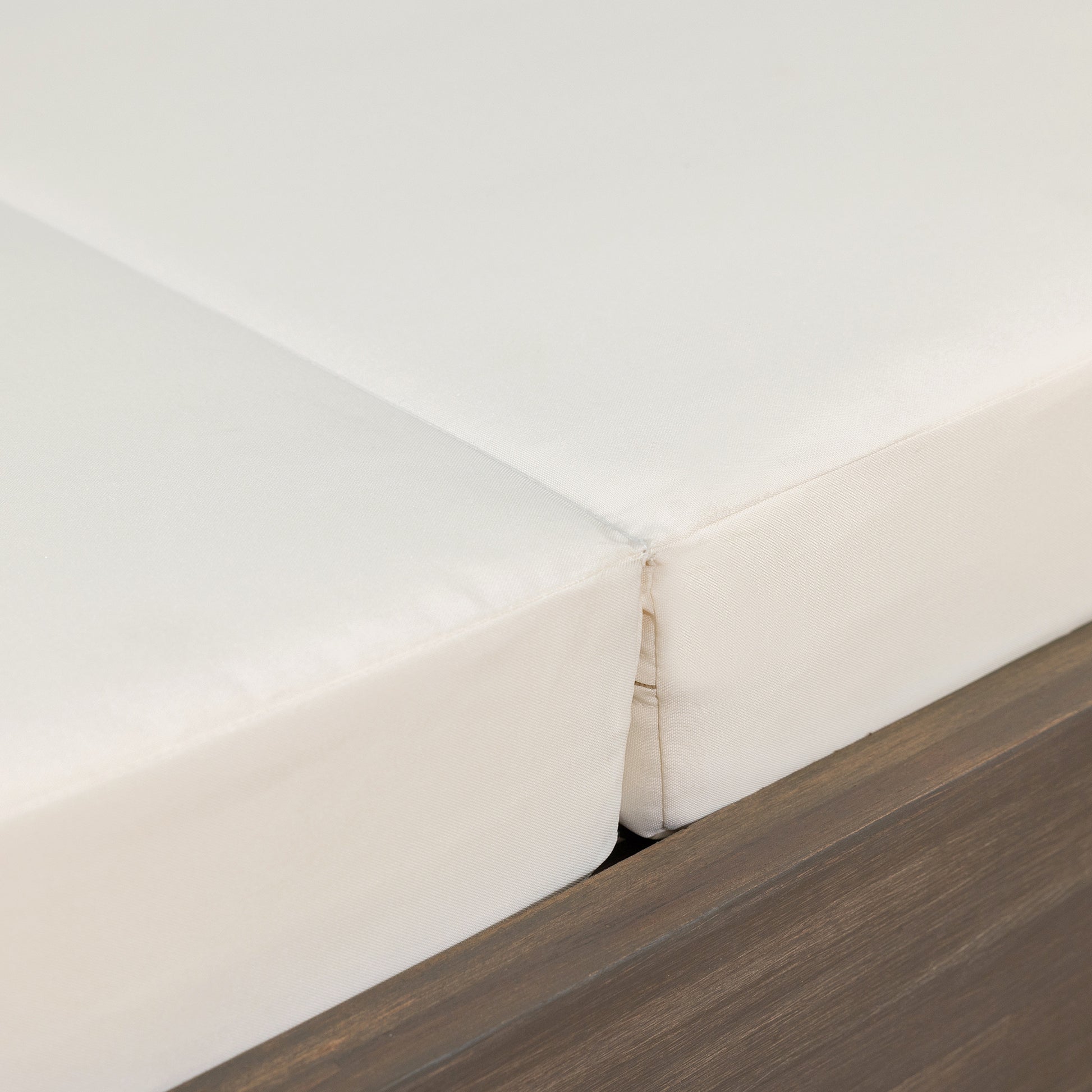 Closeup of a white outdoor furniture cushion with a subtle texture revealing a hidden seam detail for durability