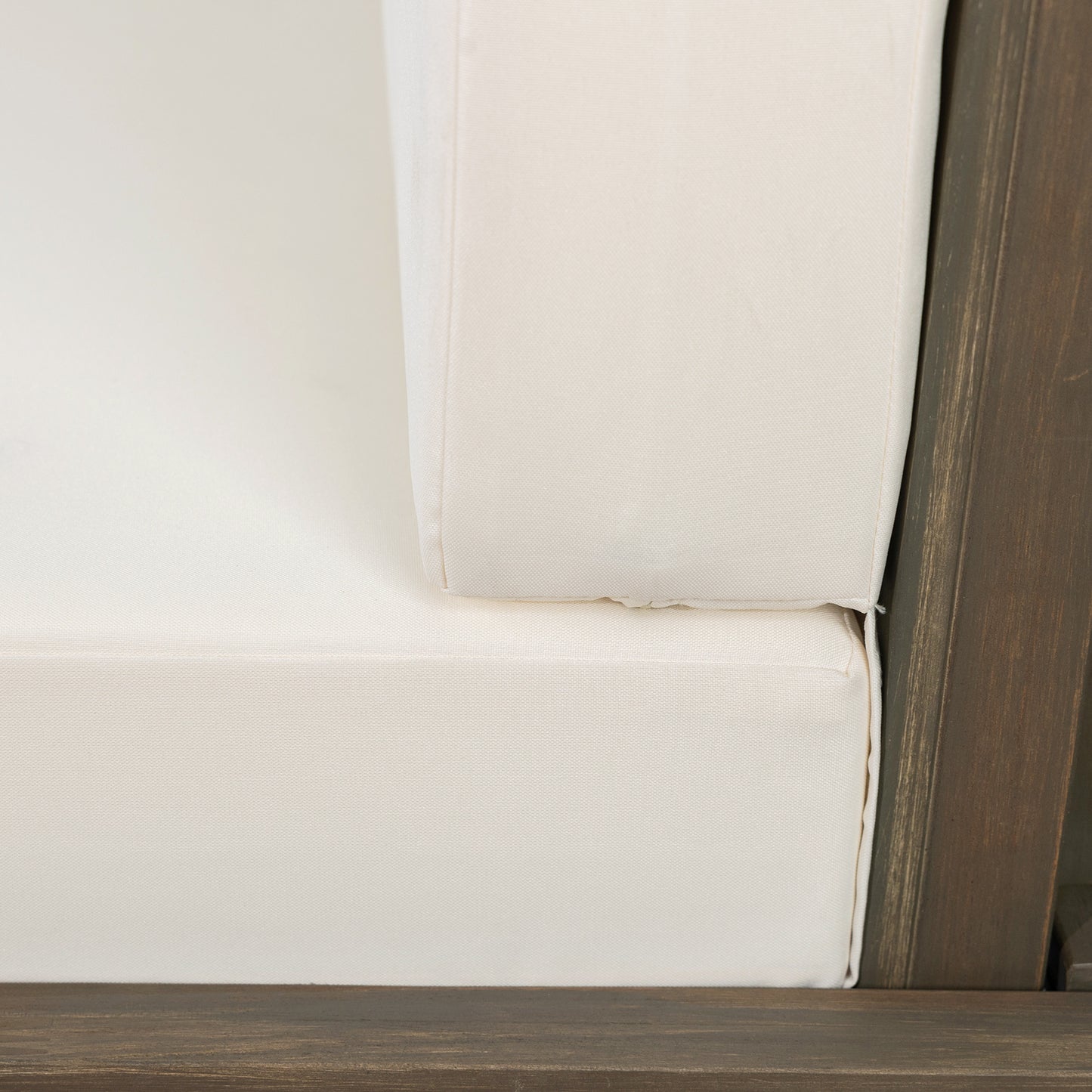 Cream upholstered couch cushion with dark wood frame detail