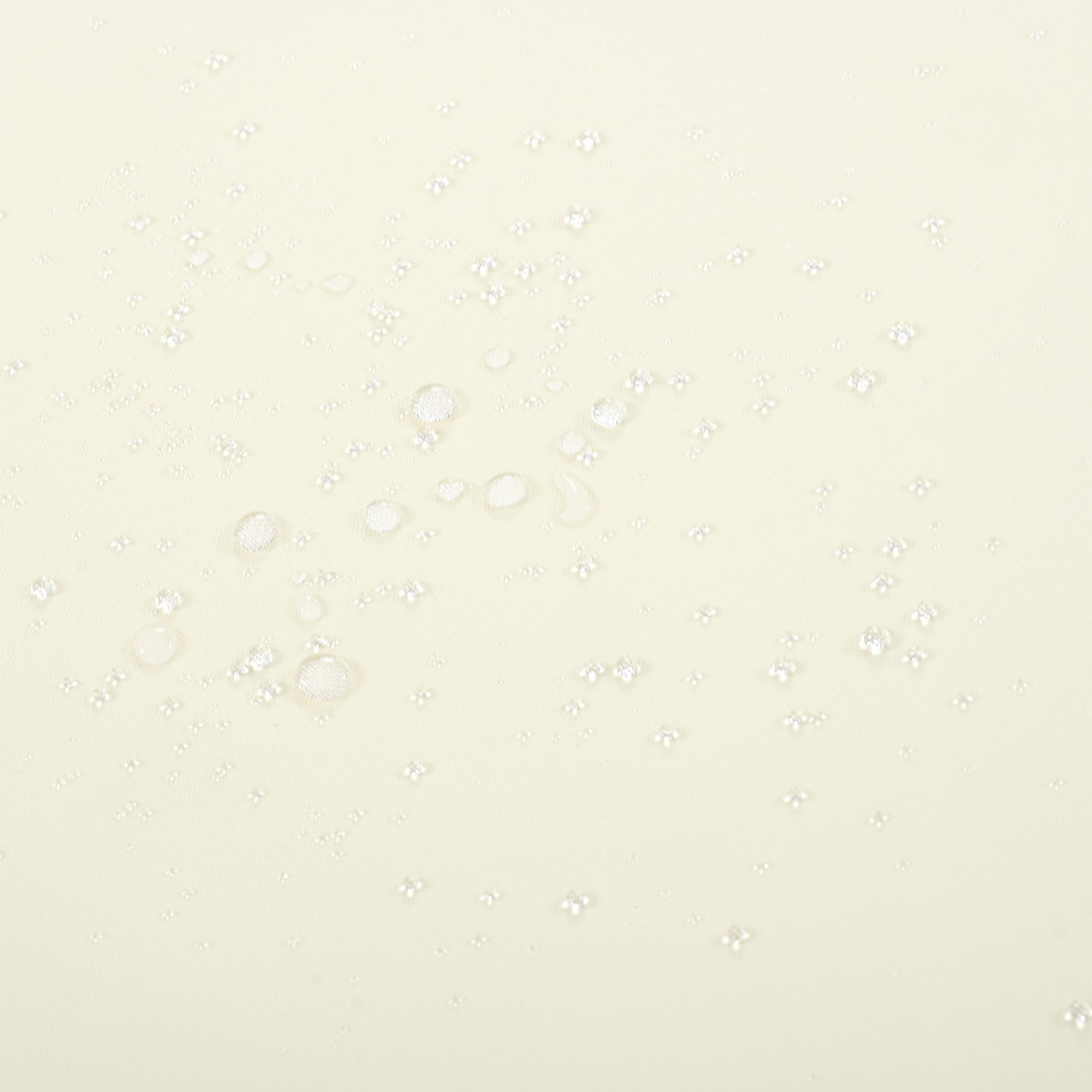 Closeup of translucent water droplets on a creamcolored fabric surface