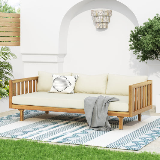 Modern acacia wood outdoor sofa with beige cushions and gray throw blanket