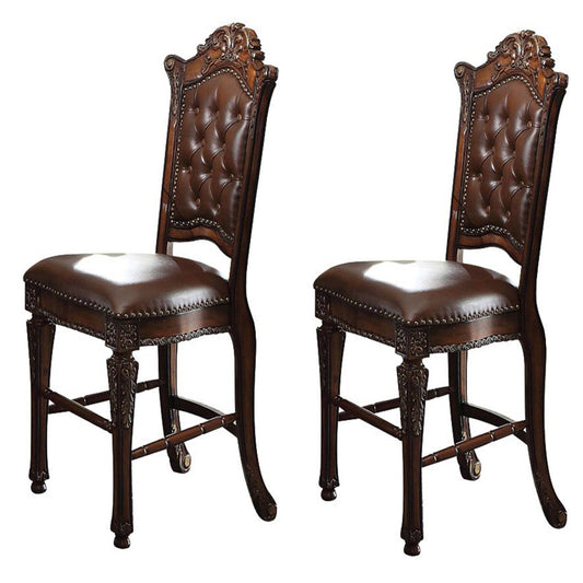 Two ornate brown leather dining chairs with tufted backs and carved wooden legs