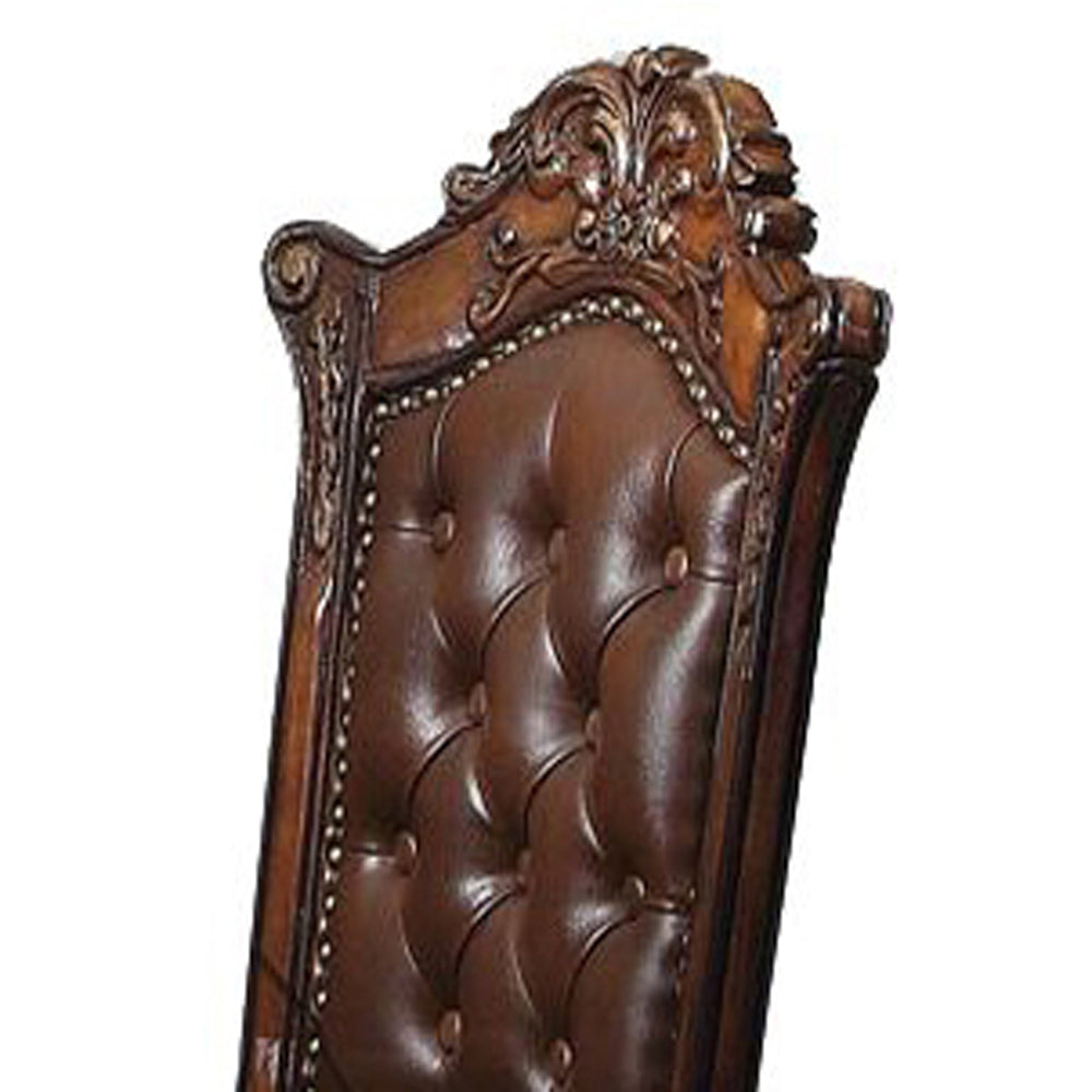 Tufted brown leather chair back with ornate carved wood frame detail