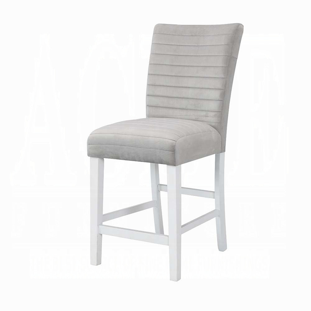 Grey upholstered bar stool with channel tufting on the back and white wooden legs