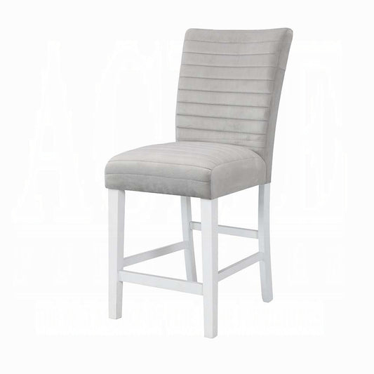 Grey upholstered bar stool with channel tufting on the back and white wooden legs