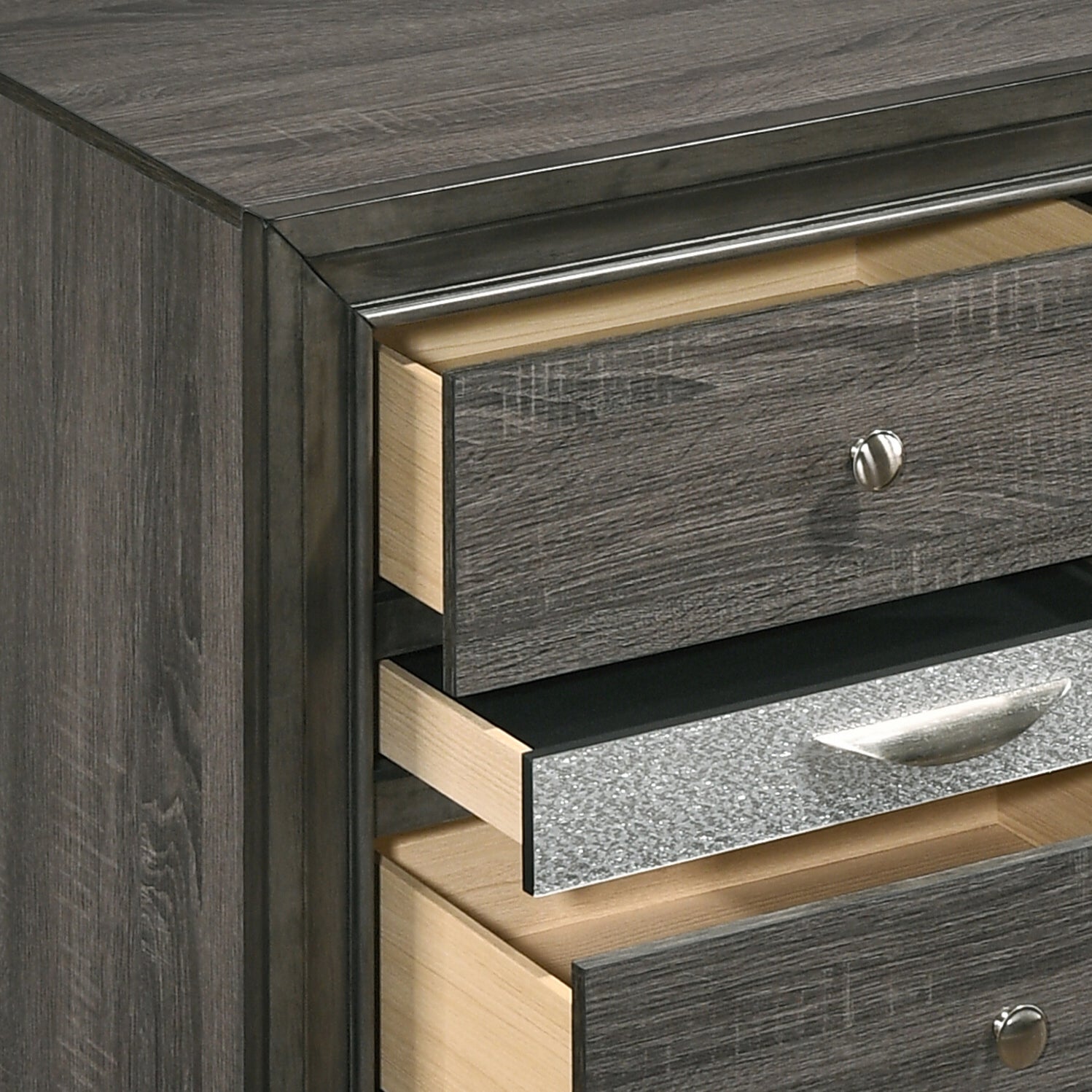 Dark grey distressed wood dresser with three open drawers and silver hardware