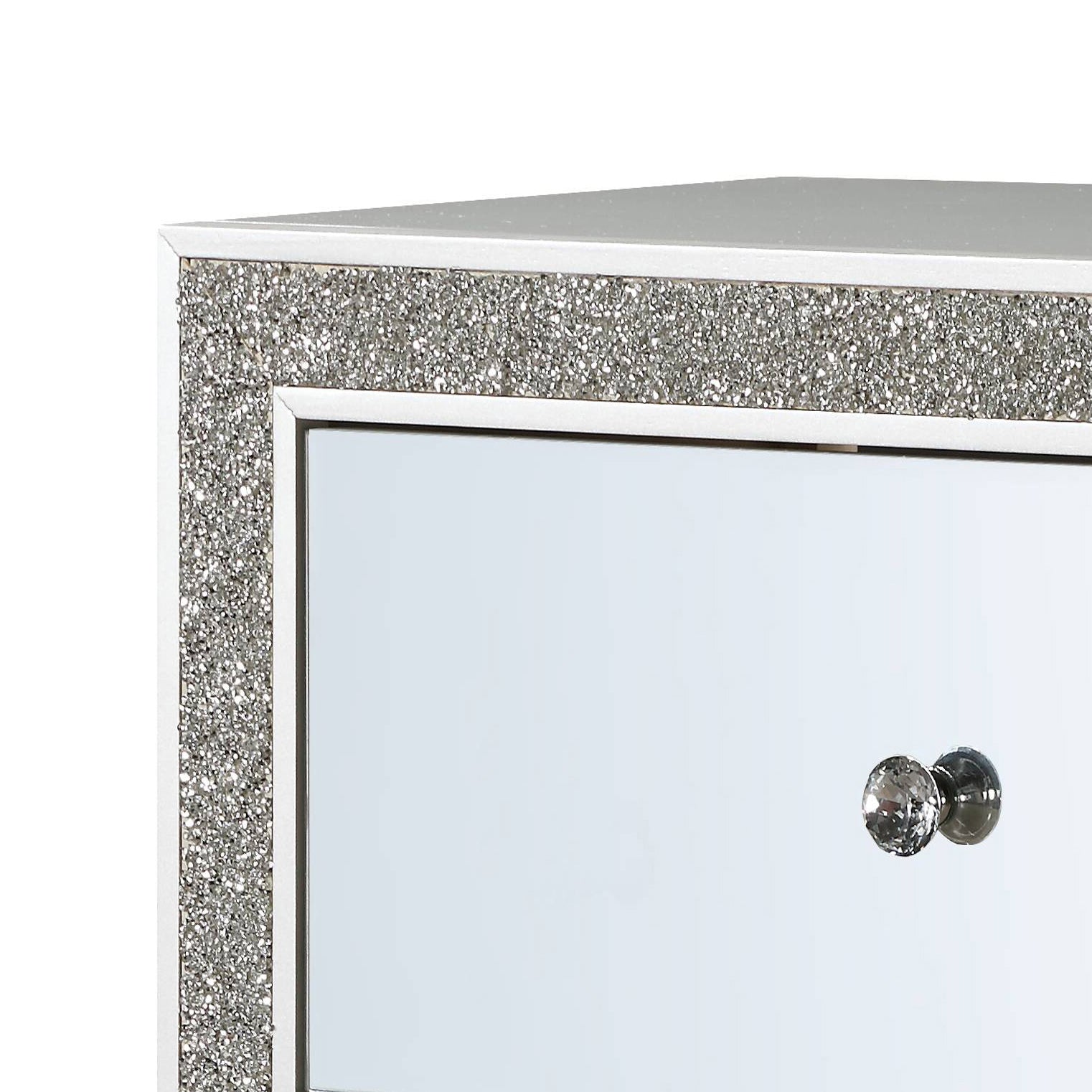 Closeup of a white mirrored dresser drawer front with crystal knobs