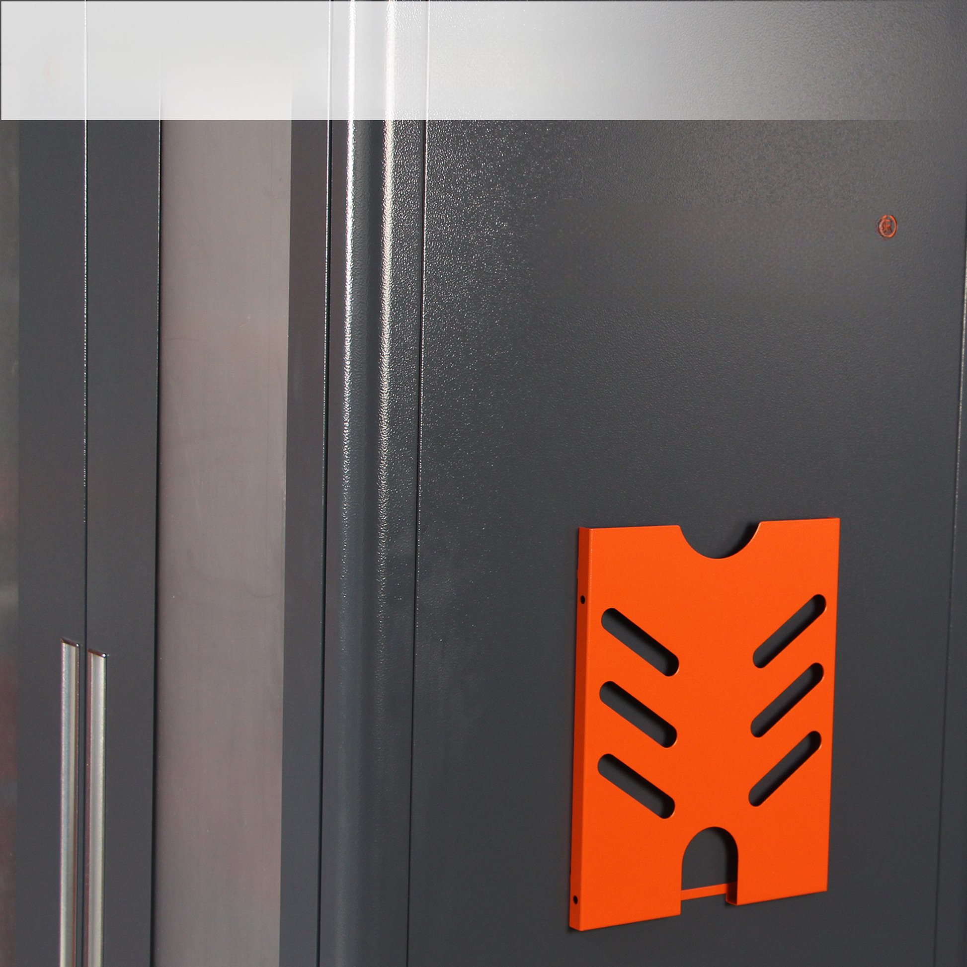 Orange metal sheet holder with cutout slots attached to a dark gray cabinet