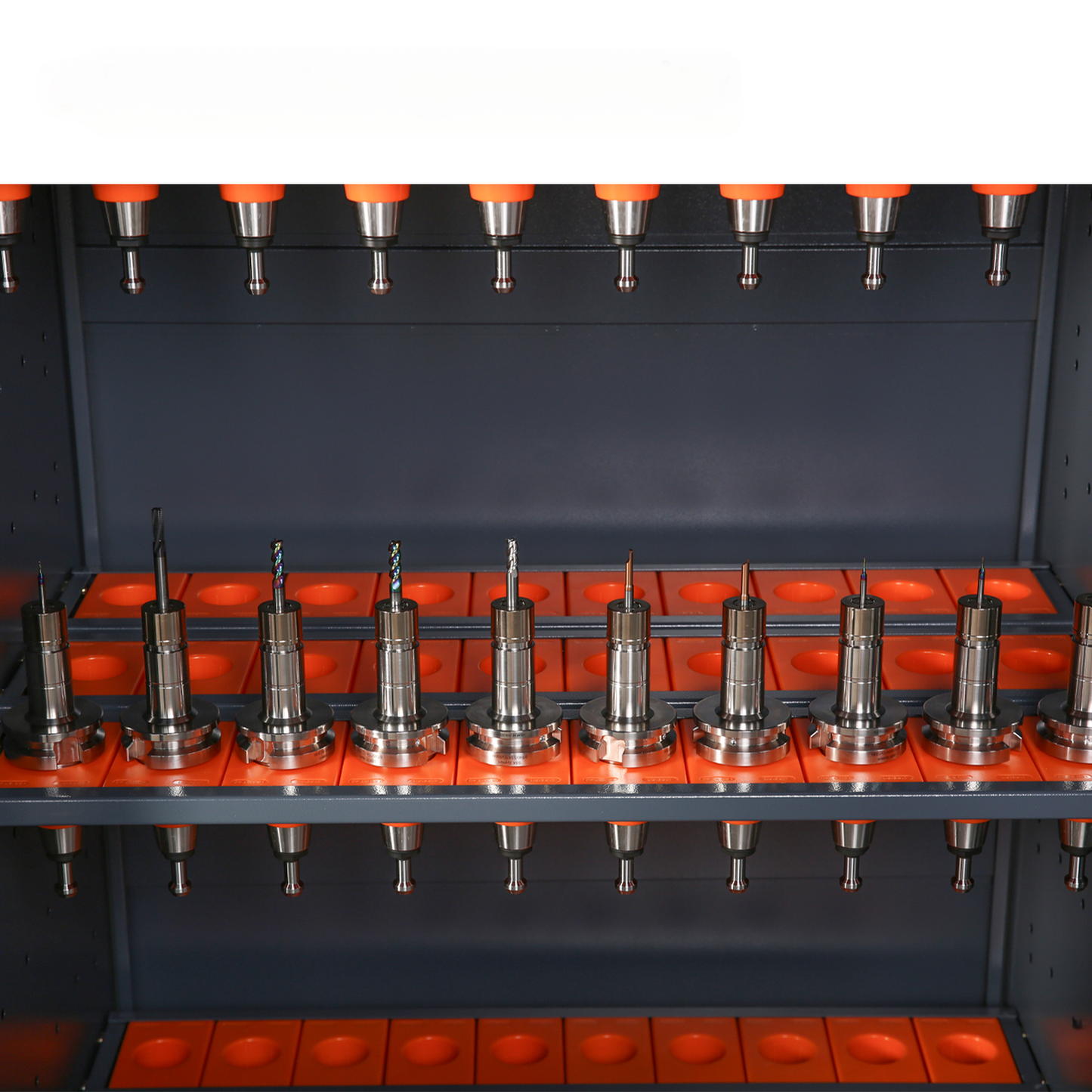 Variety of metal CNC tool holders with orange caps organized in racks