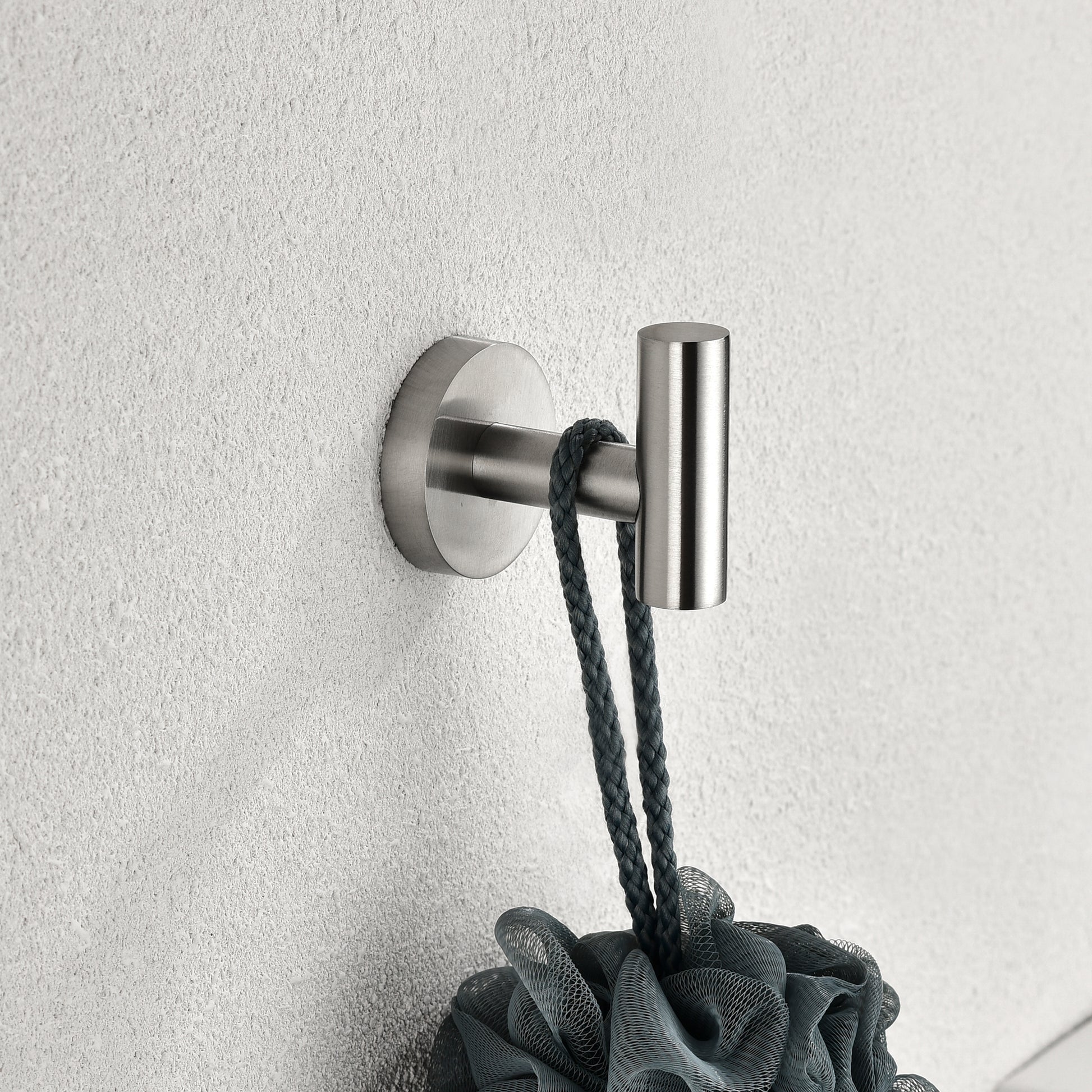 Brushed nickel bathroom hook holding a dark grey loofah