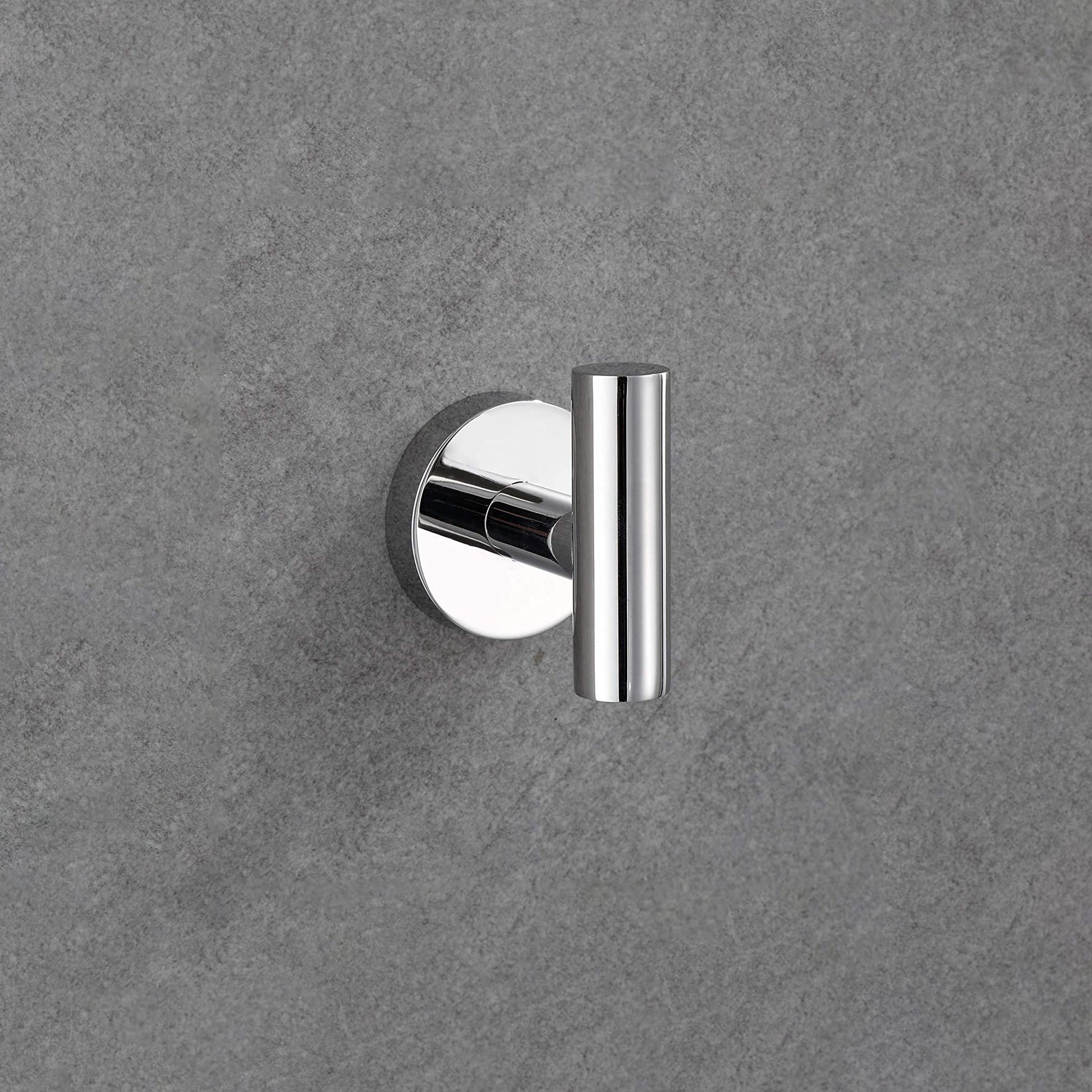 Polished chrome single robe hook on textured grey wall