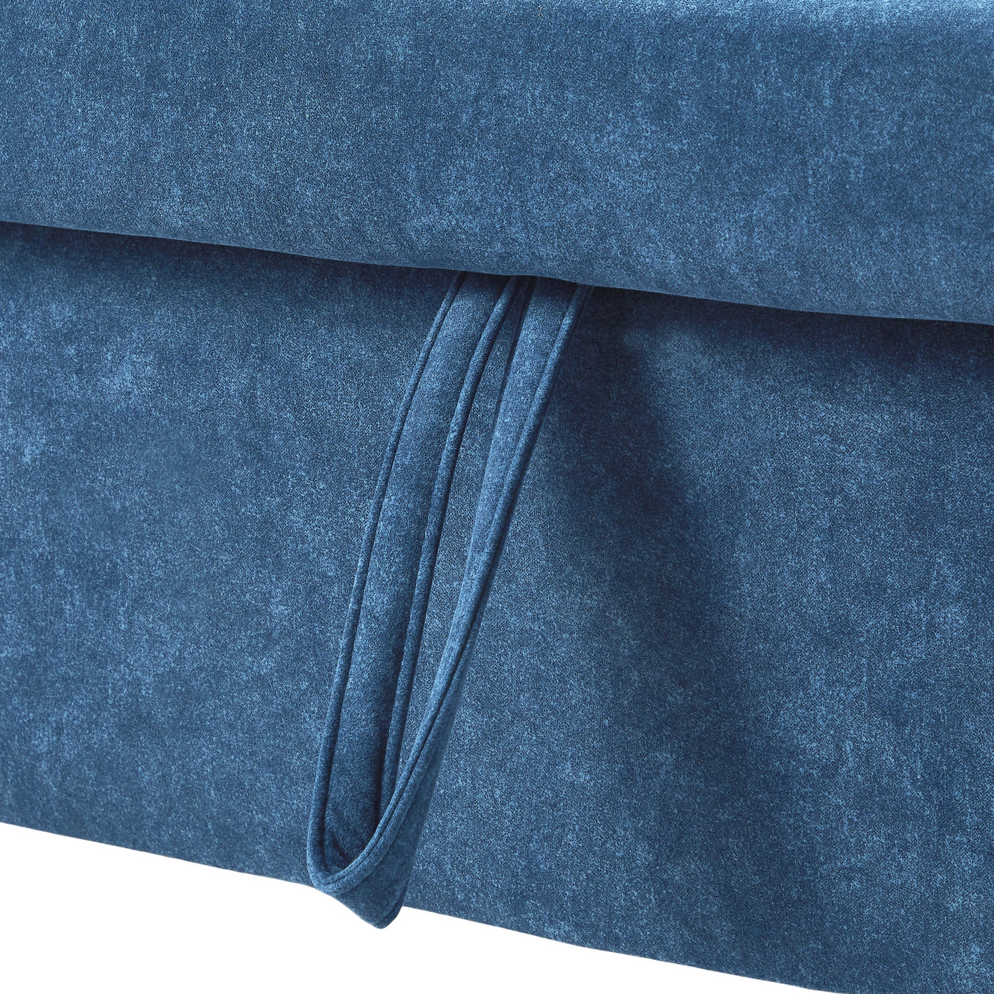 Closeup of textured blue velvet fabric on a sofa with a pull tab detail