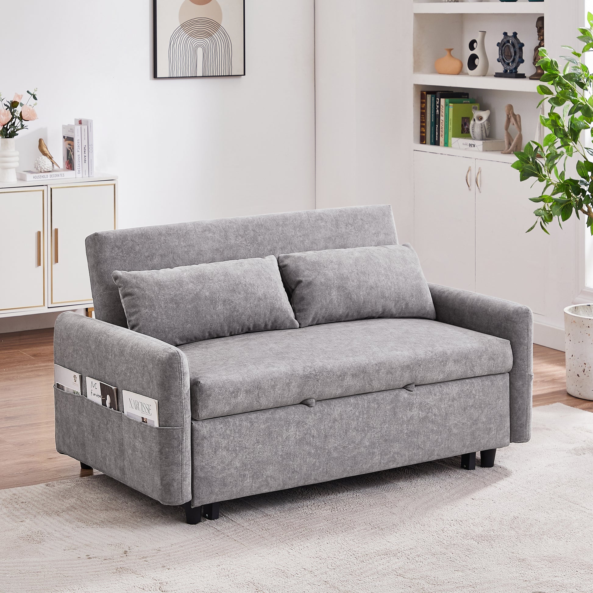 Grey fabric sofa bed with two plush cushions and side magazine pockets perfect for small spaces