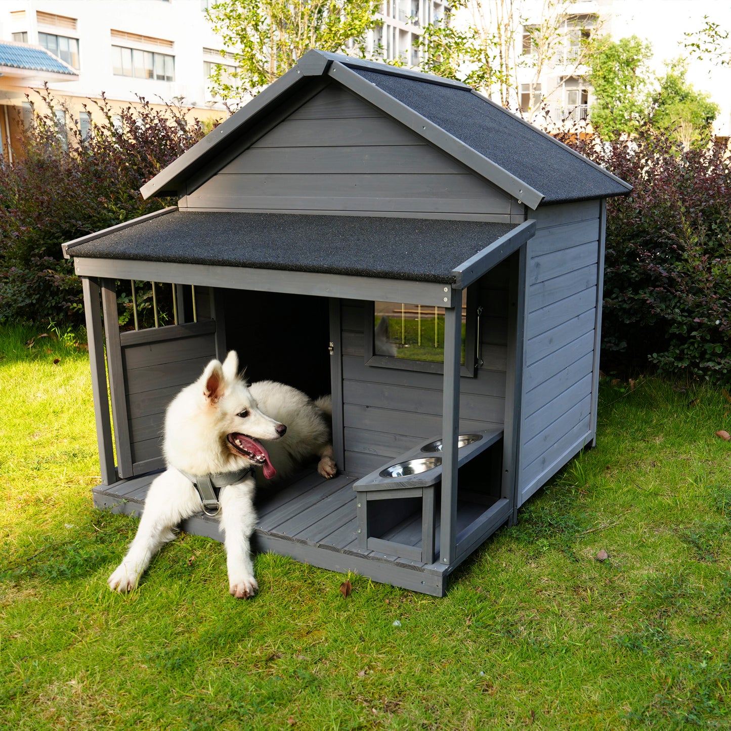 Gray wooden dog house with elevated food bowls and a comfortable porch for outdoor pets