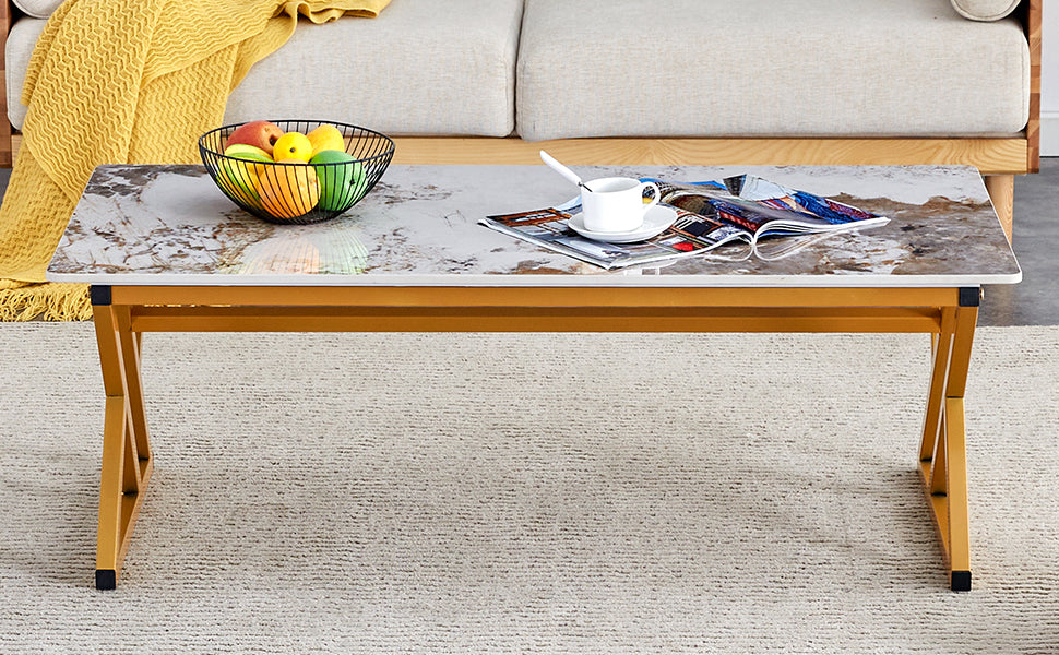 Modern marble top coffee table with gold legs a fruit bowl and magazines