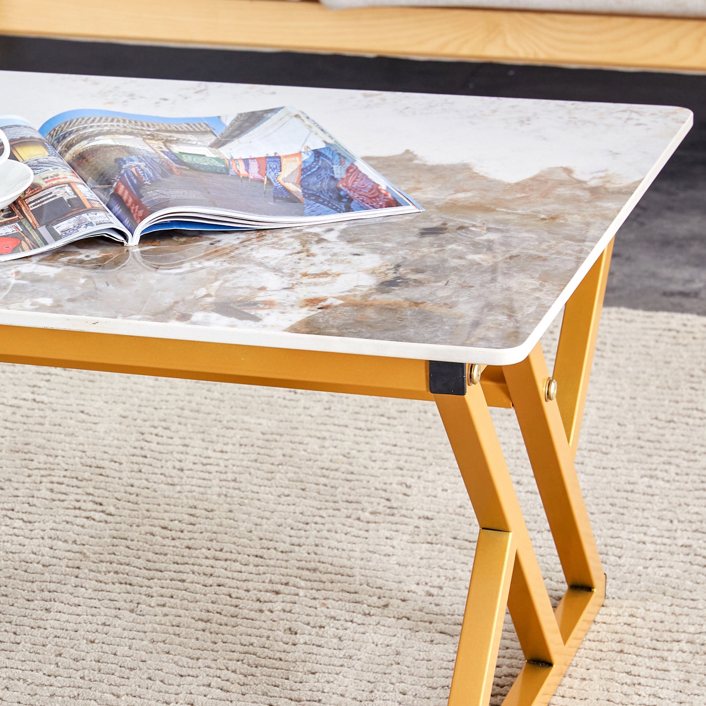 Marble effect coffee table with gold legs and open magazine