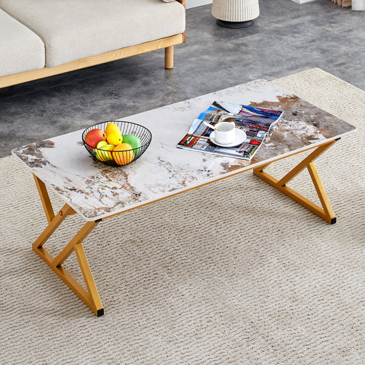 Modern faux marble coffee table with gold geometric legs and a fruit bowl